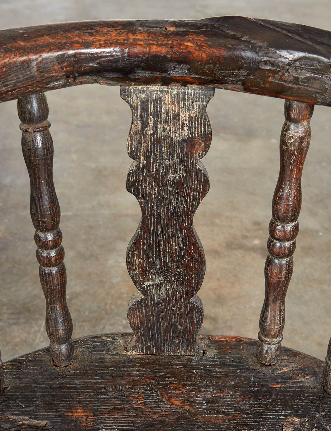 Fauteuil rustique de chalet alpin suisse, de forme traditionnelle, avec un dossier et des accoudoirs arqués et sculptés, avec des poignées en forme d'escargot en spirale, sur trois lattes plates sculptées et six lattes tournées, sur un siège en