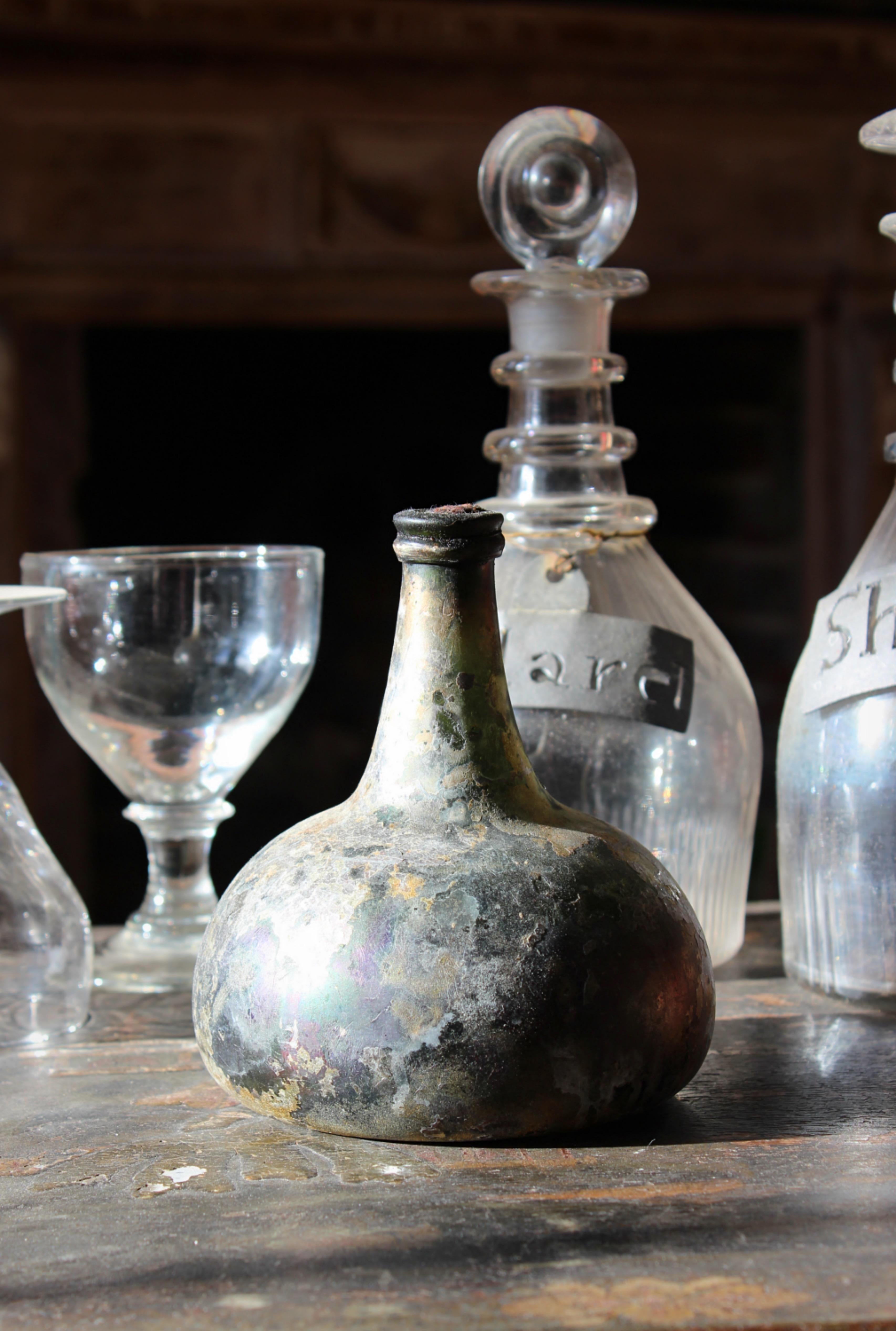 Dutch “ onion “ bottle, salvaged from the shipwreck of Vliegend Hert circa 1981. 

The bottle has a large amount of its original contents contained by its original cork but does weep if tipped.

The bottles surface is beautifully iridescent from