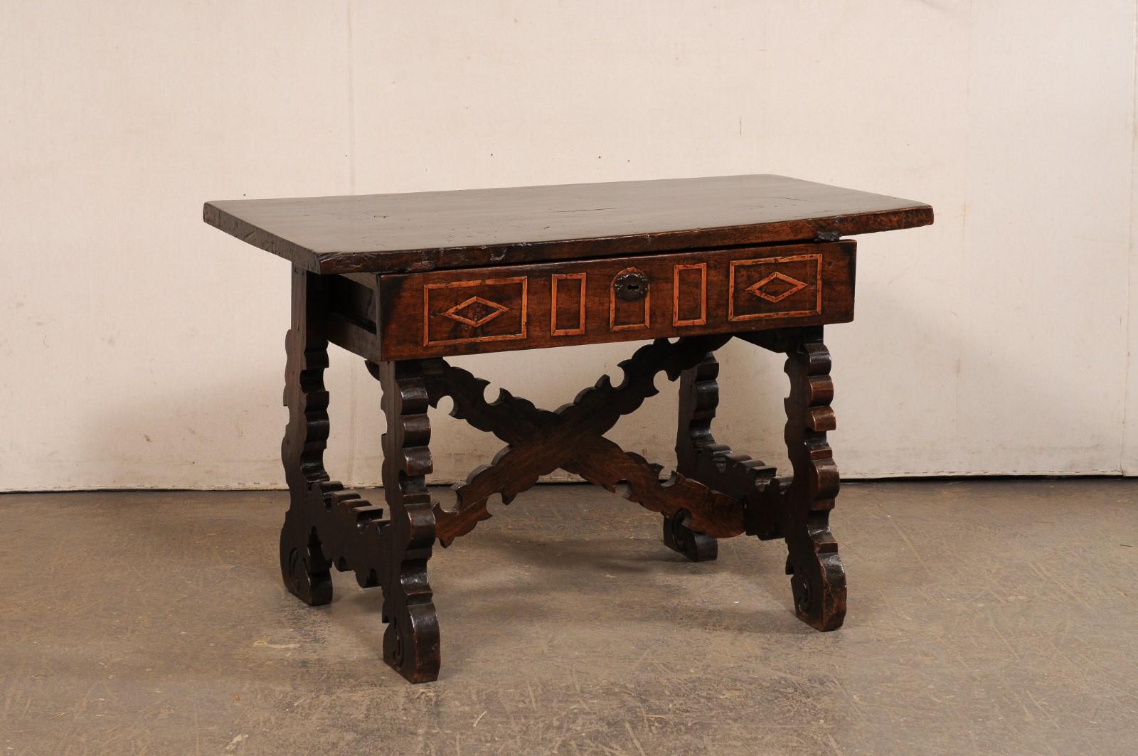 A Spanish carved-wood occasional table with drawer from the 18th century. This antique table from Spain has a rectangular-shaped top, over an apron which houses a single drawer along one side, which is adorn in geometric carvings and mimicked on the