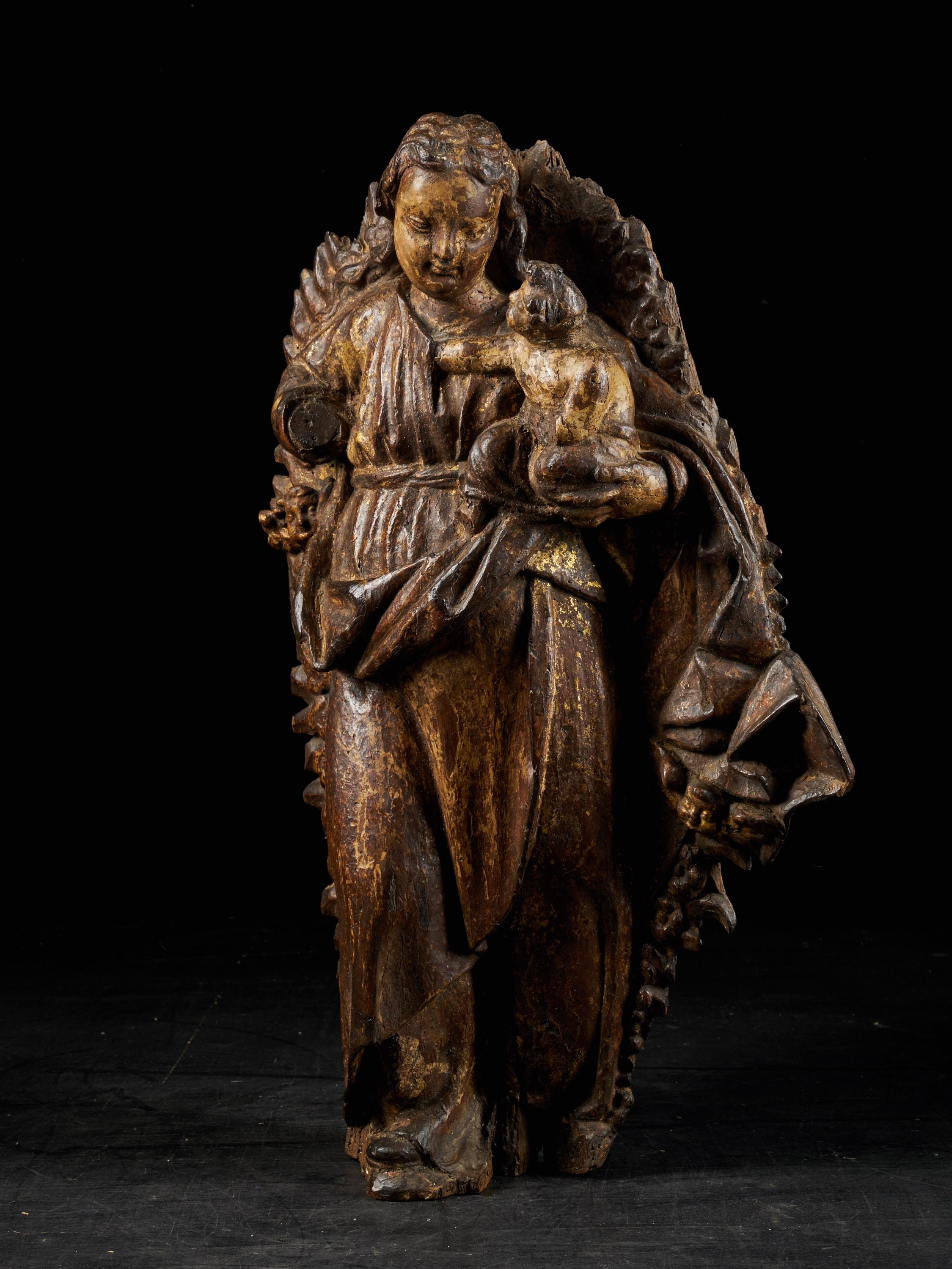 The wooden relief is sculpted out of one piece and consist of two figures. The Virgin Maria, encircled by a wooden relief structure, holds the child Jesus in her left arm. Dating from 18th century Spain, this gilded wooden relief sculpture has a