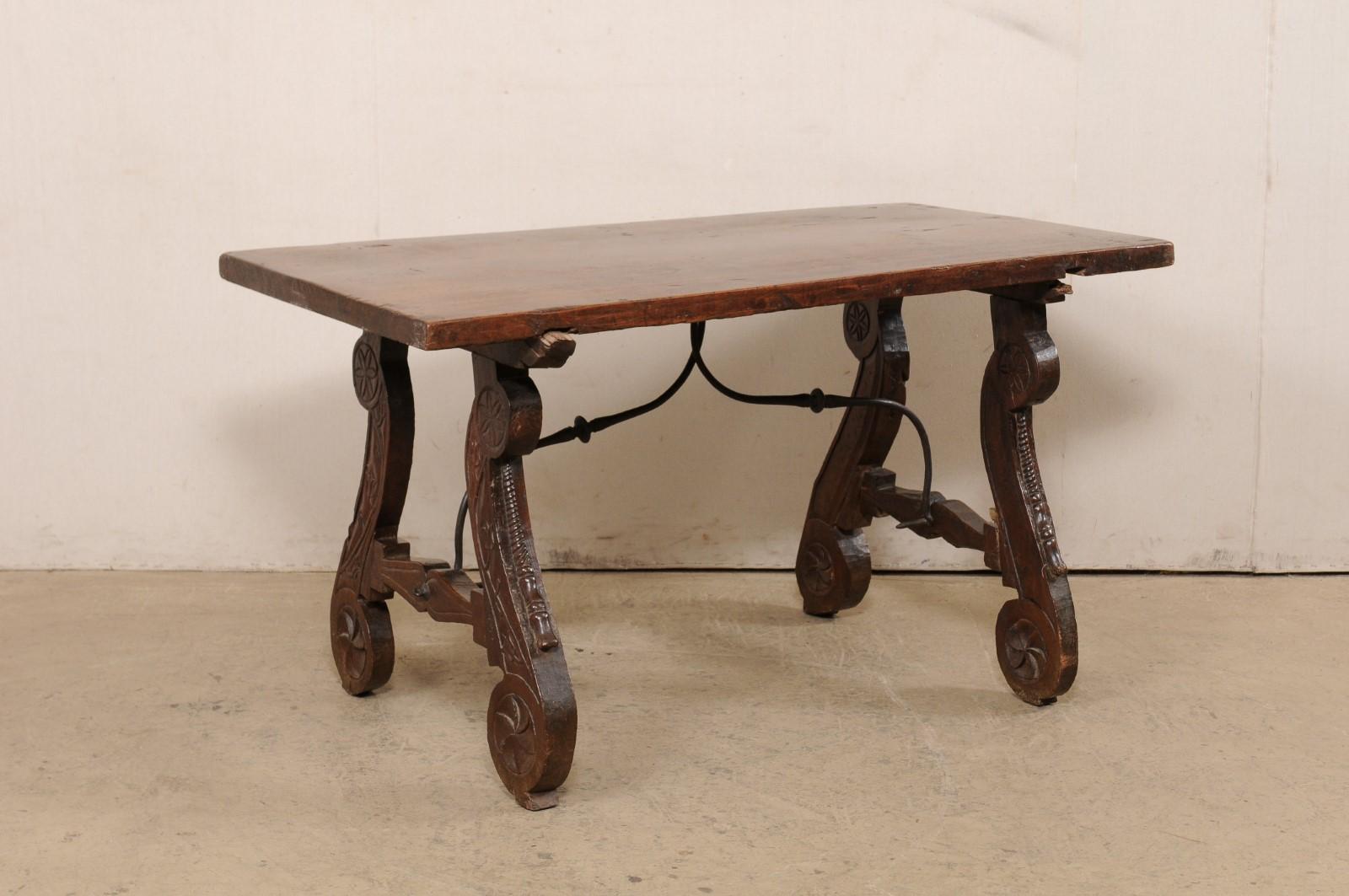 A Spanish walnut wood stretcher table, with beautifully carved lyre legs, from the 18th century. This antique table from Spain features a rectangular-shaped top which is comprised of a single board, raised upon a pair of scrolling lyre-legs with