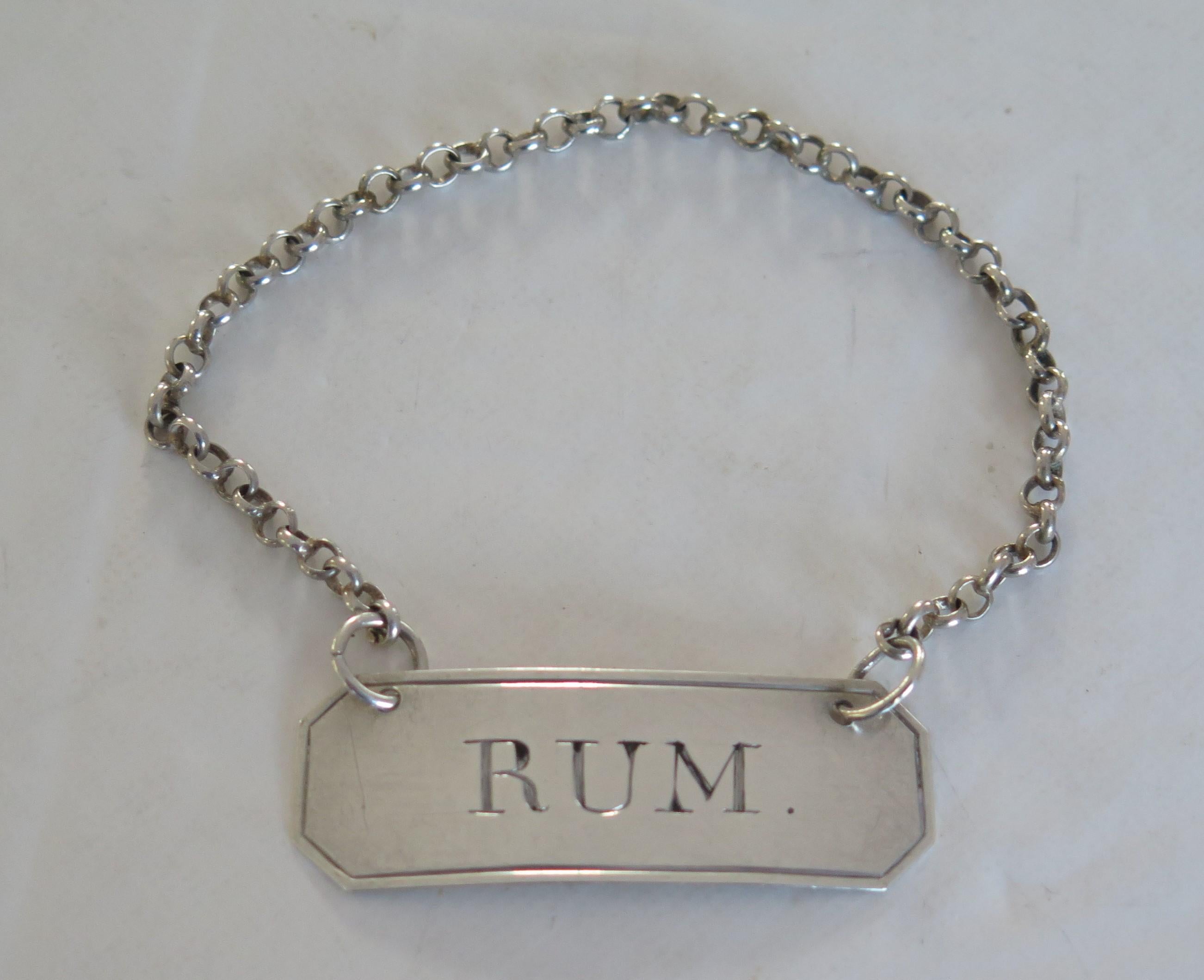 This is a solid, cast, English sterling silver wine label, marked RUM made by Thomas Willimore, of Birmingham, in 1815. (18th century George 111 period)

The label has a nice canted oblong shape, with a curved profile to wrap around a