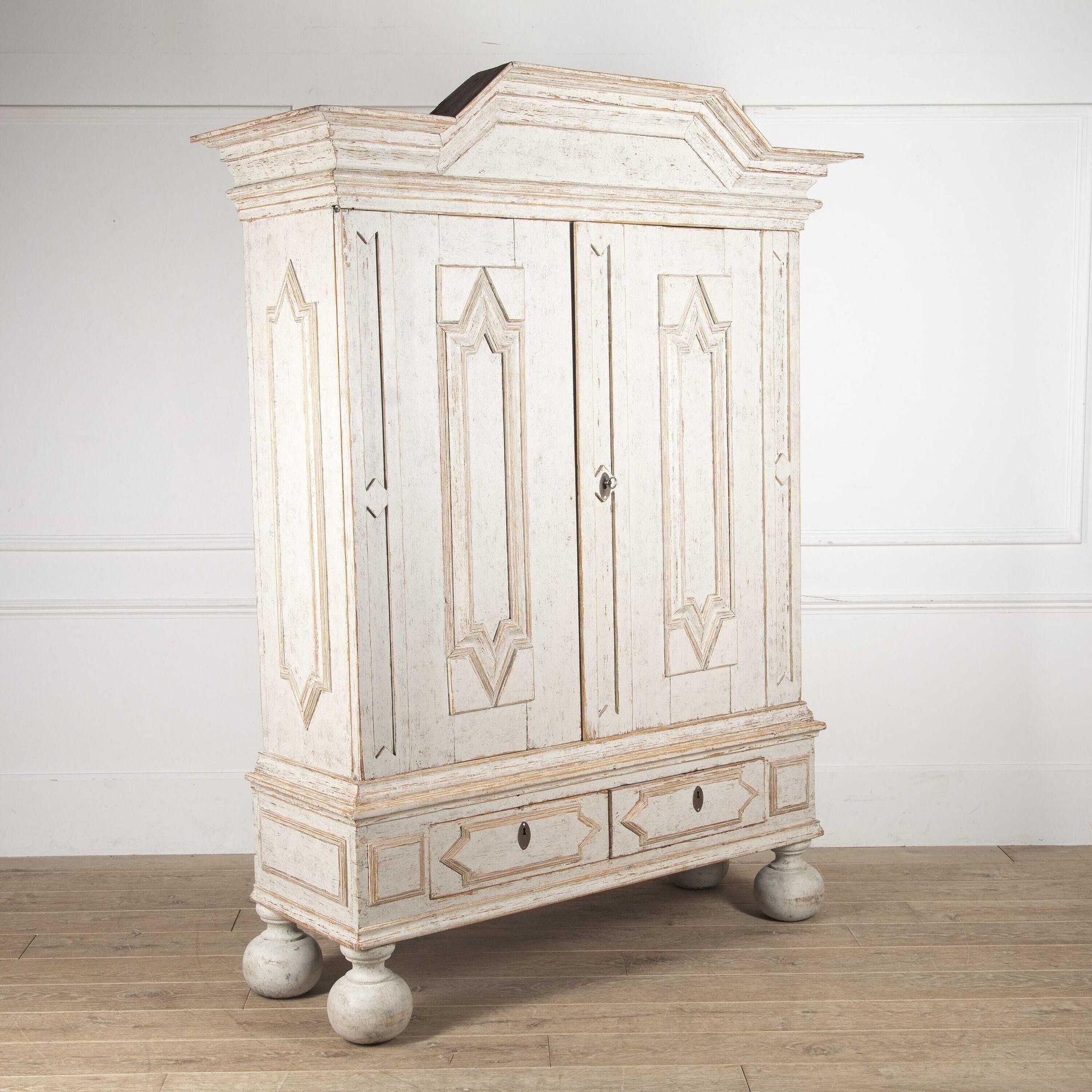 Beautifully carved Swedish painted cabinet from the Baroque period, circa 1740, with a decorative pediment and carved diamond detailing on the doors and sides. Two large doors open to the interior which is painted in a variety of blue shades with