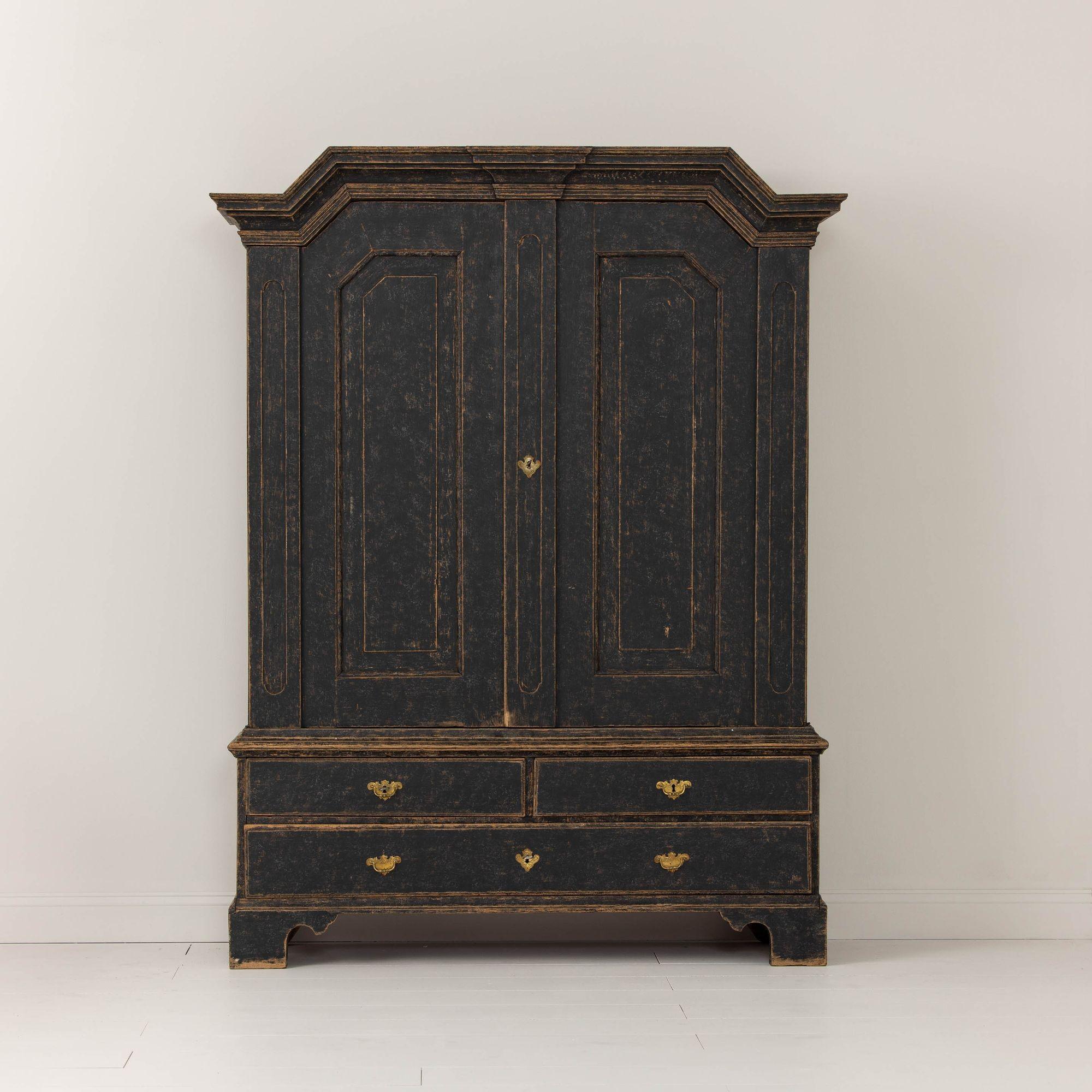 A Swedish black painted linen press from the Baroque period, circa 1750. This piece is made in five parts for easy of transport (lower base, upper frame, 2 doors, and cornice top). Original cast brass hardware. Beautifully proportioned with a shaped