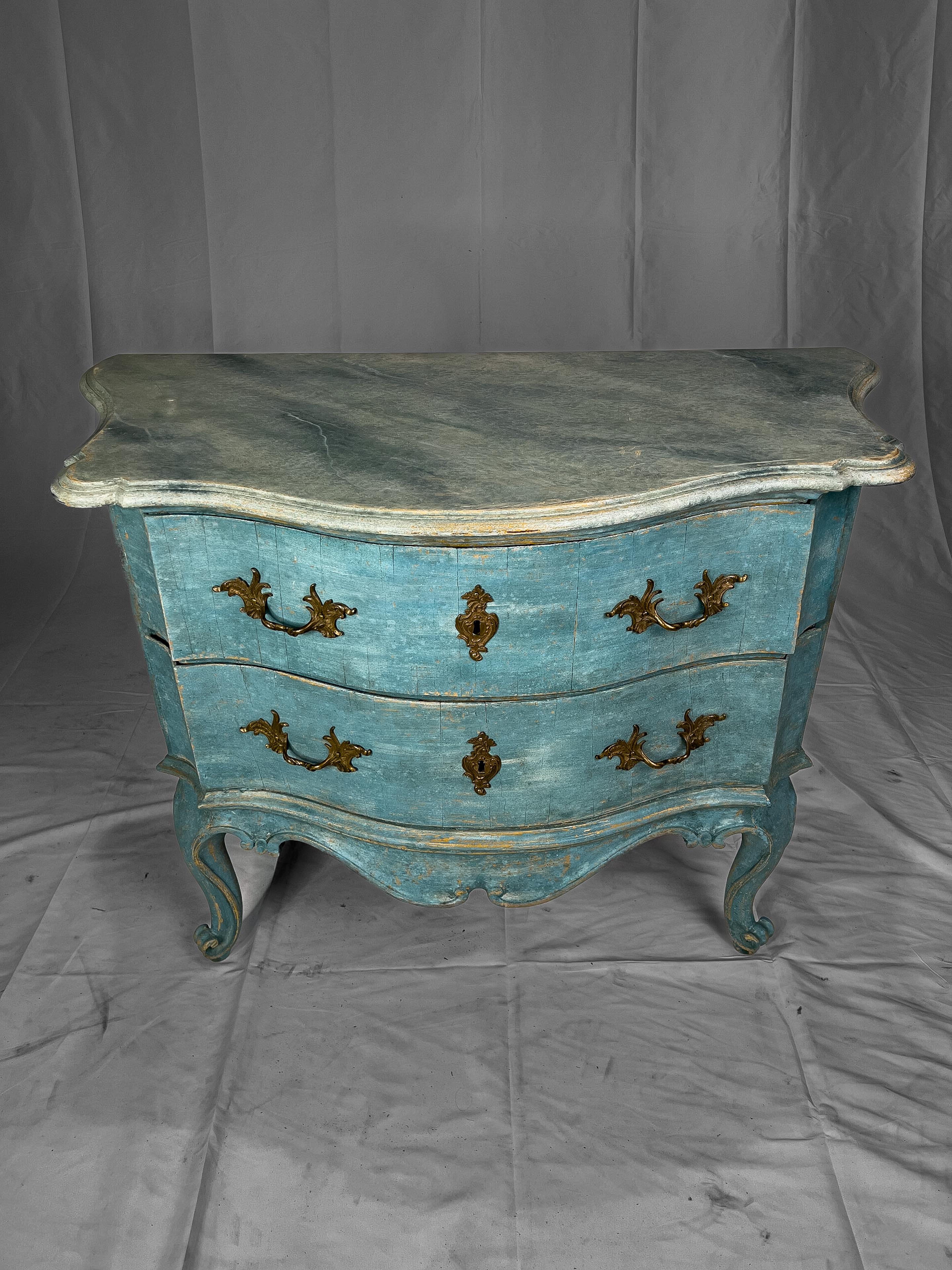 18th c. Swedish Commode with a serpentine shape, cabriole legs and a decorative painted finish. The top surface is painted to resemble marble. The drawers have Rococo style hardware.