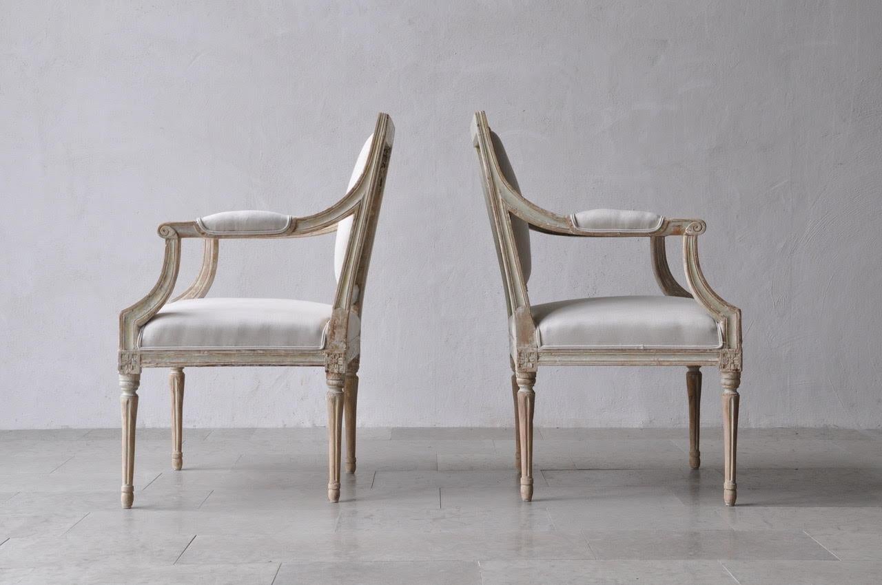 A period pair of Stockholm made Gustavian armchairs in original paint. These beautiful chairs have been newly upholstered in new linen. Classic Gustavian chairs with lovely lean lines.