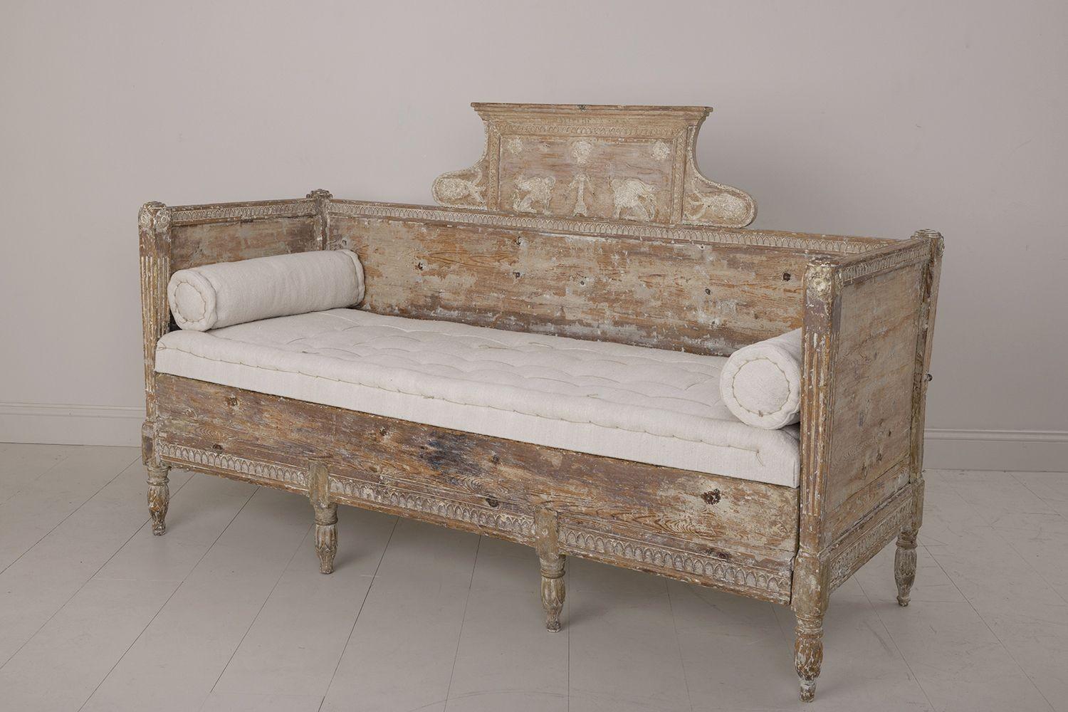 An exceptionally rare, hand-carved Swedish Gustavian period sofa or daybed, circa 1790, hand-scraped to reveal the original paint surface and newly upholstered in antique linen with a hand-stitched tufted seat and side bolster pillows. Beautiful