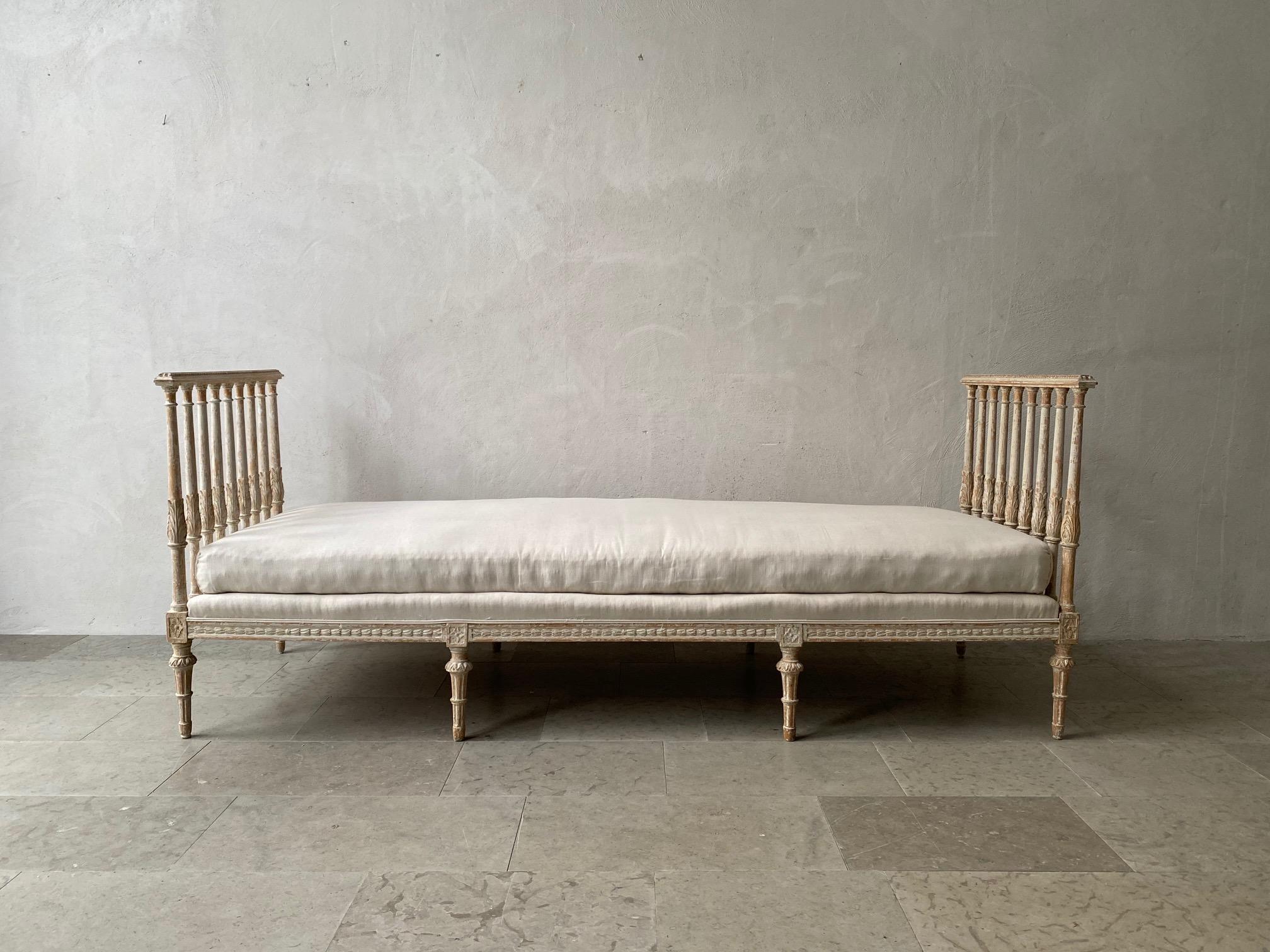 A carved Swedish Gustavian period daybed, signed ILG for Johan Lindgren, Stockholm. Johan was a master chair maker in Stockholm from 1740-1800. This beautiful, circa 1780 daybed has been hand-scraped to reveal the original paint surface and newly