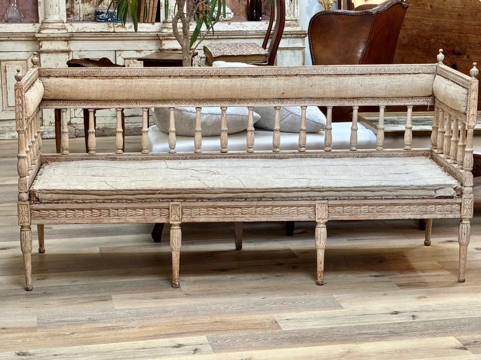 18th C. Swedish Gustavian Settee or Bench c. 1790. Having original paint.  The beautifully foliate carved back supported by  turned and foliate spindles over a rectangular seat with floral carvings over turned legs having further foliate carving. 

