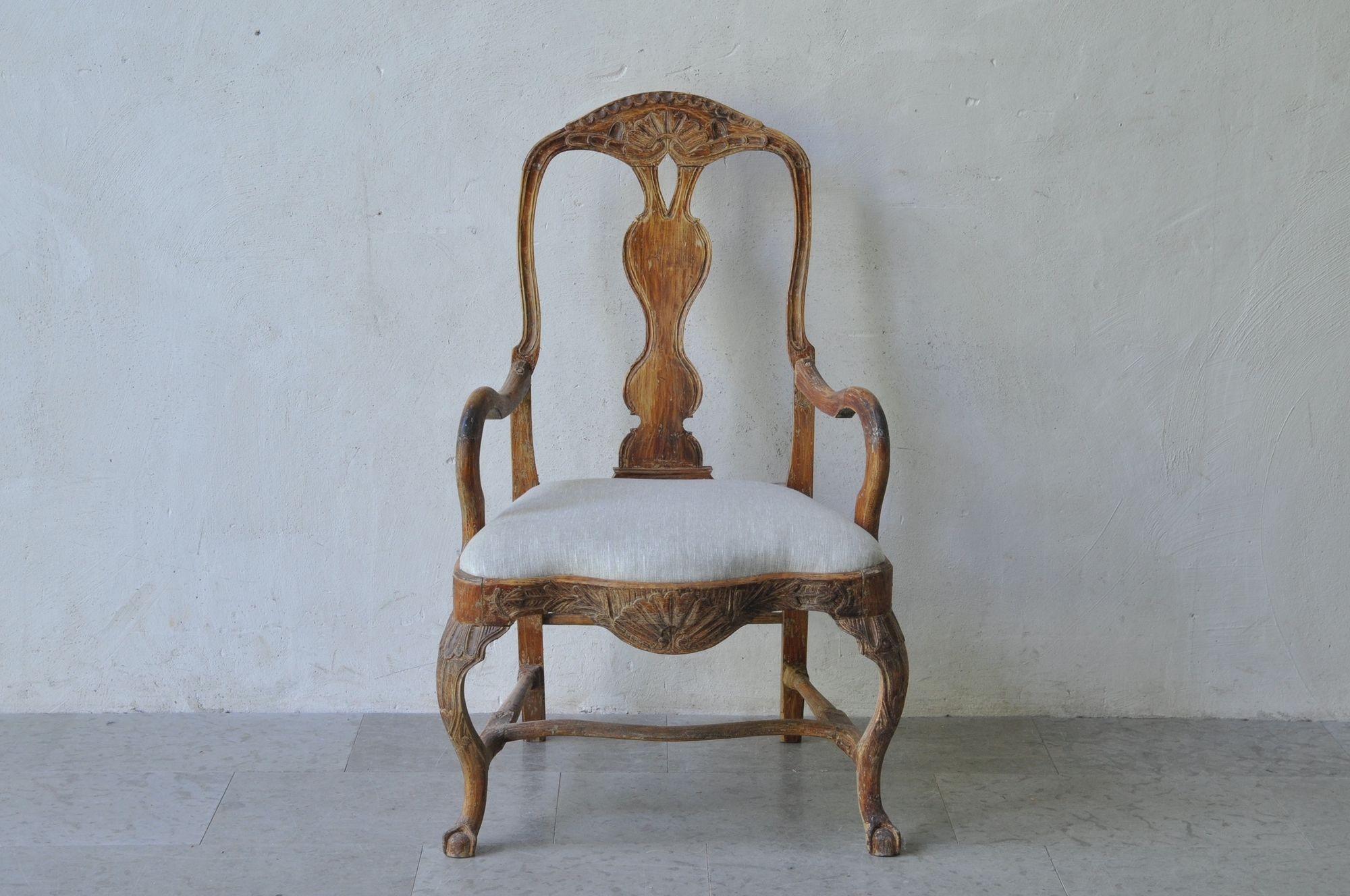 An 18th c Rococo period armchair from Lindome, Sweden, hand-scraped to the original paint and newly upholstered in linen. Lovely shell motif on the back and seat frame with cabriole legs terminating in claw-and-ball foot with shaped, H-stretcher