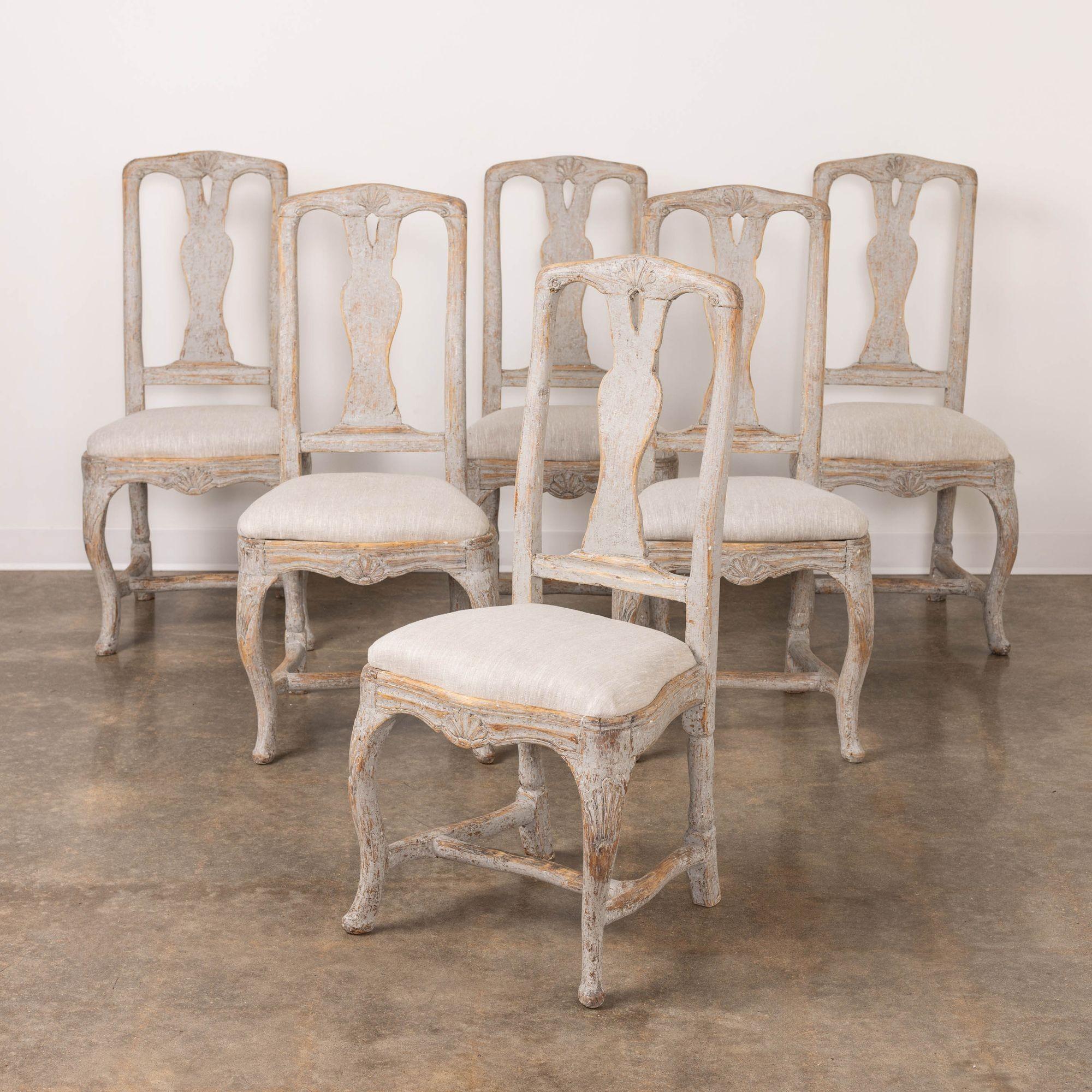 A very fine set of six Swedish dining chairs from the Rococo period, newly upholstered in linen with pierced splat backs, shell motif on the backs, seat frames, and legs, carved and shaped seat rail, refined cabriole legs, H-stretcher, and sip