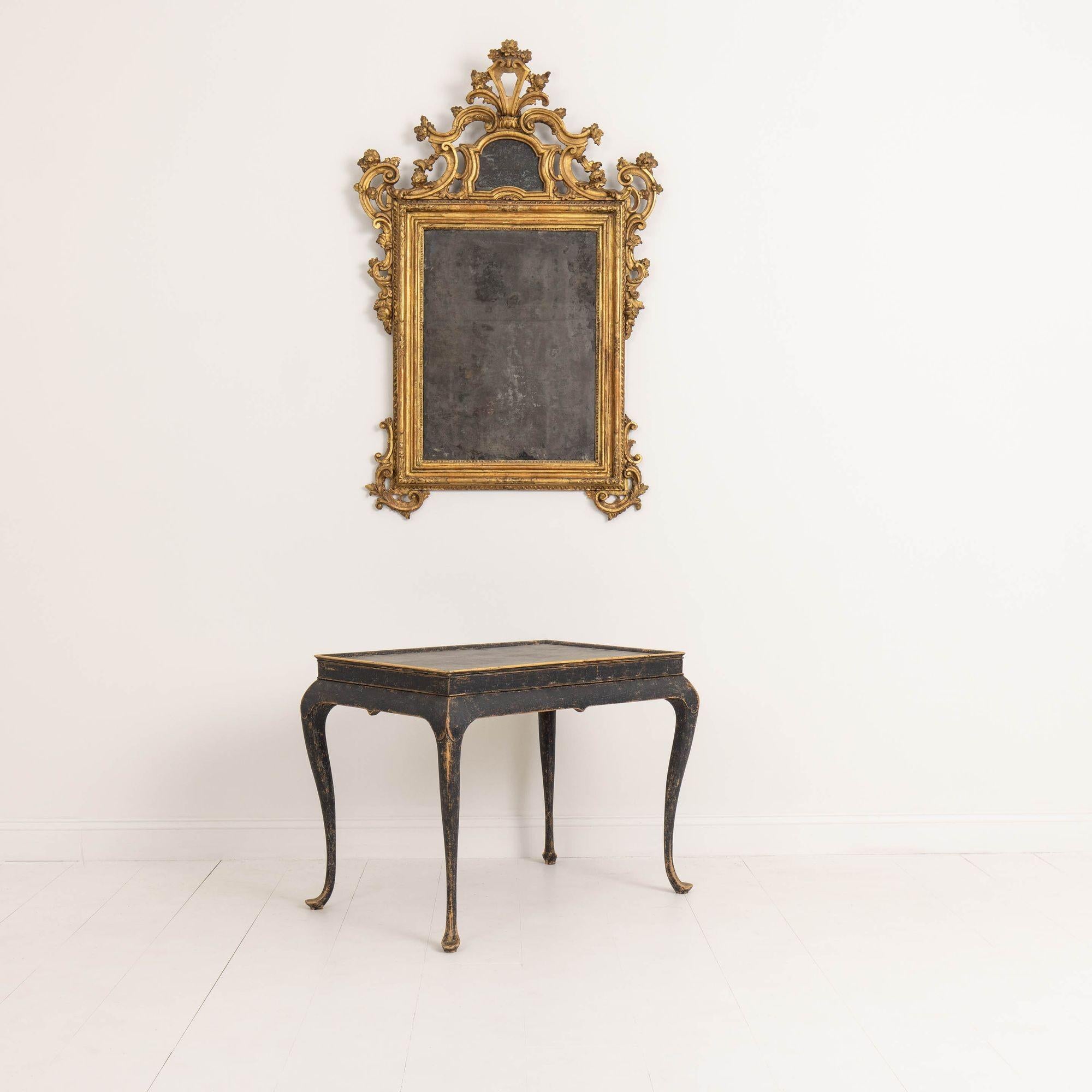 An 18th c. Swedish tea table from the Rococo period, circa 1760. Beautiful, aged black paint with traces of natural wood showing through in areas. Tray top with decorative apron and elegant cabriole legs.