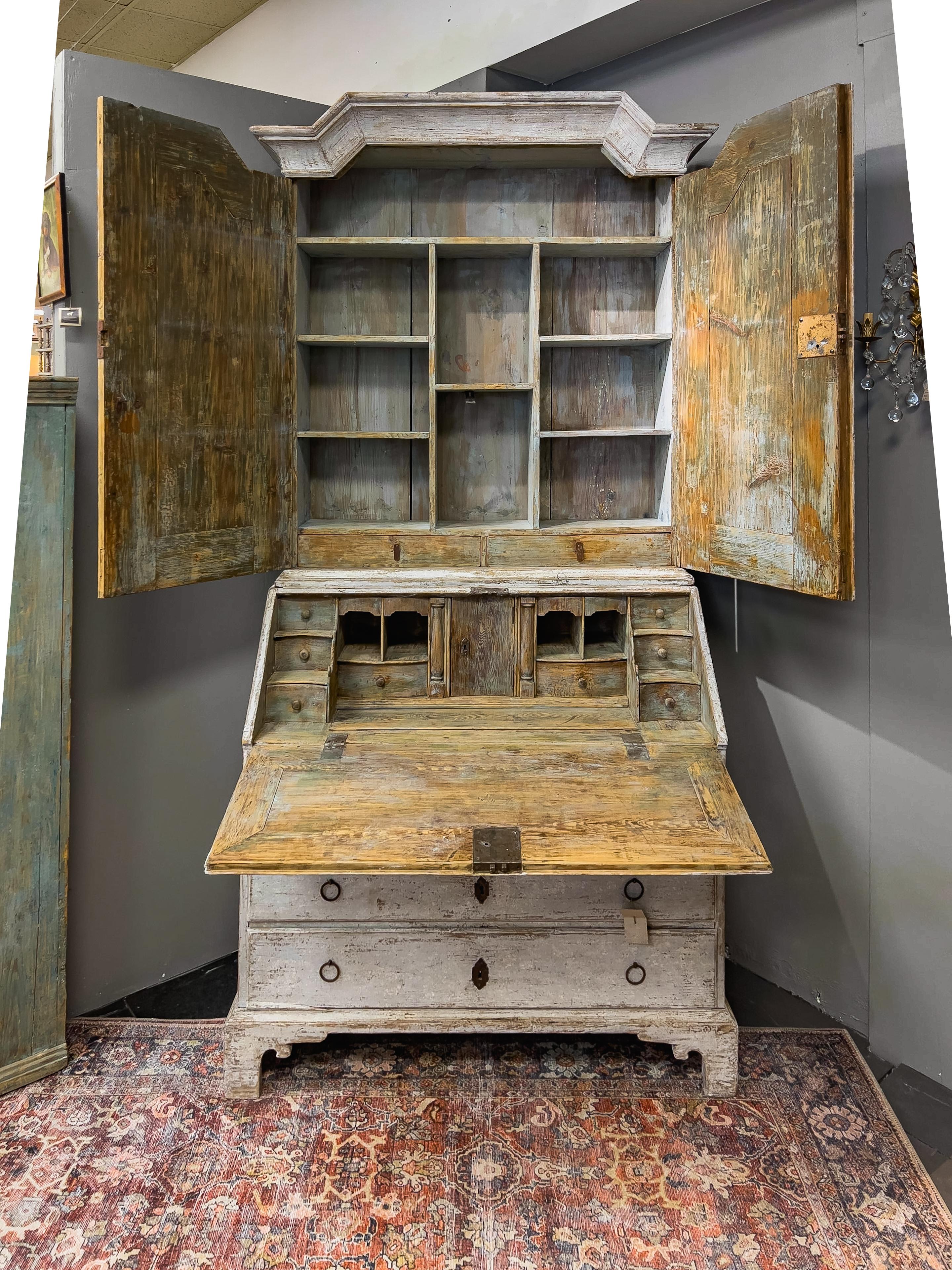 18th c. Swedish Secretary with Painted Finish having two upper doors above the fall front secretary desk and 4 bottom drawers. The interior of the upper and lower section have multiple drawers, some obvious and some concealed. 

See video and