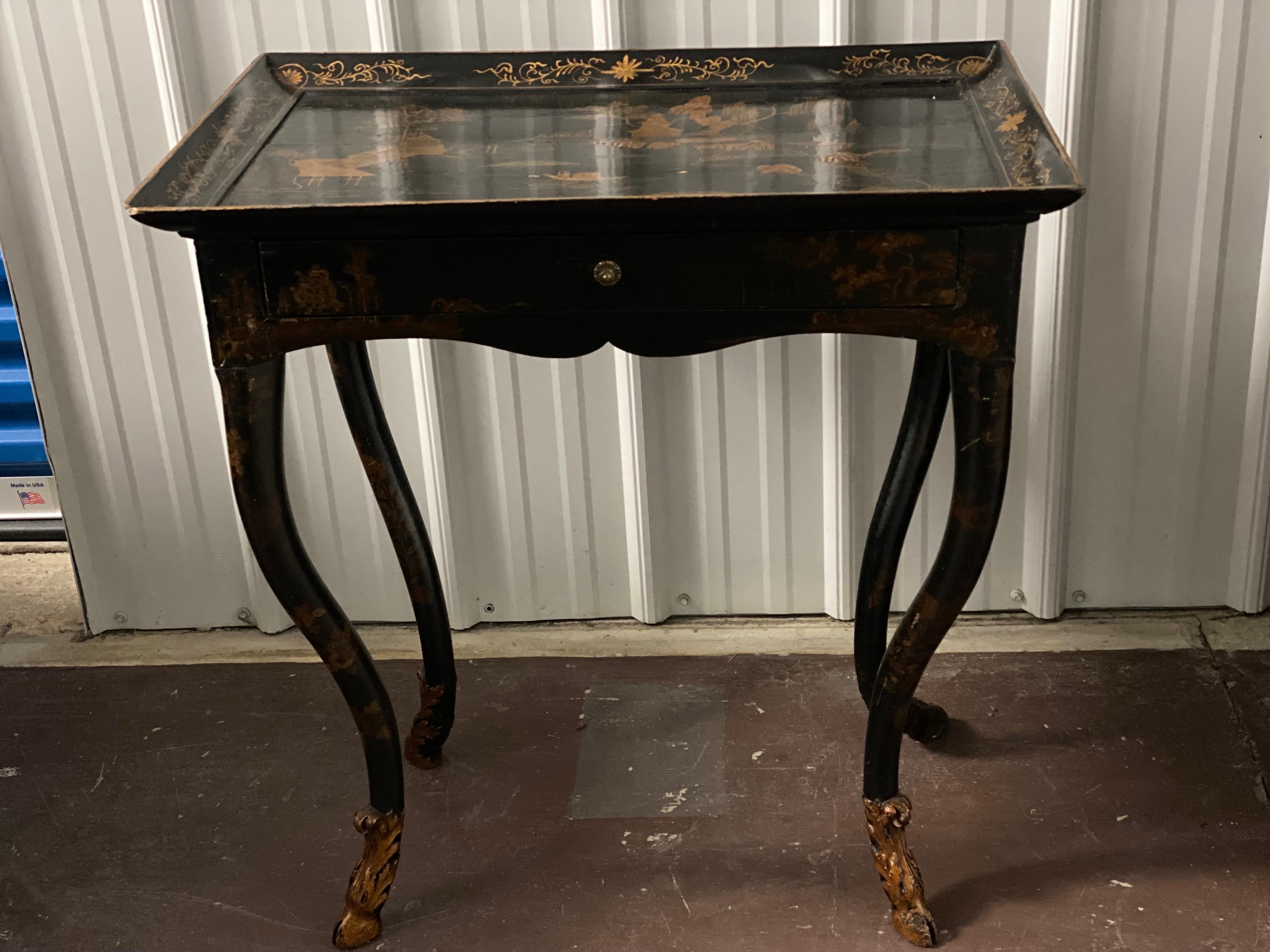 18th C. Venetian Rococo Black Lacquered Japanned Table sourced by Parish Hadley.  A charming black lacquered table with Japanning in gold paint to the top and sides. A single drawer. Rococo curved legs end in gilded hoof foliage feet. Sourced by