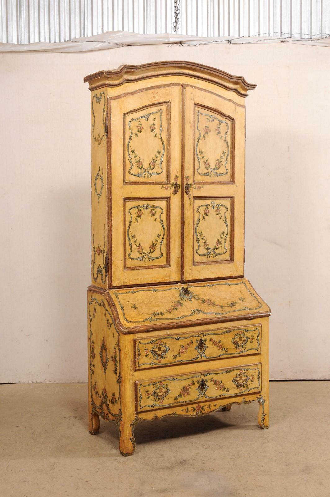 An Italian Venetian tall secretary cabinet from the 18th century. This antique 7.75 feet tall (approximate) cabinet from Venice, Italy boasts a beautifully hand-painted and embellished exterior in a floral, leaf, and scrolling cartouche motif. The