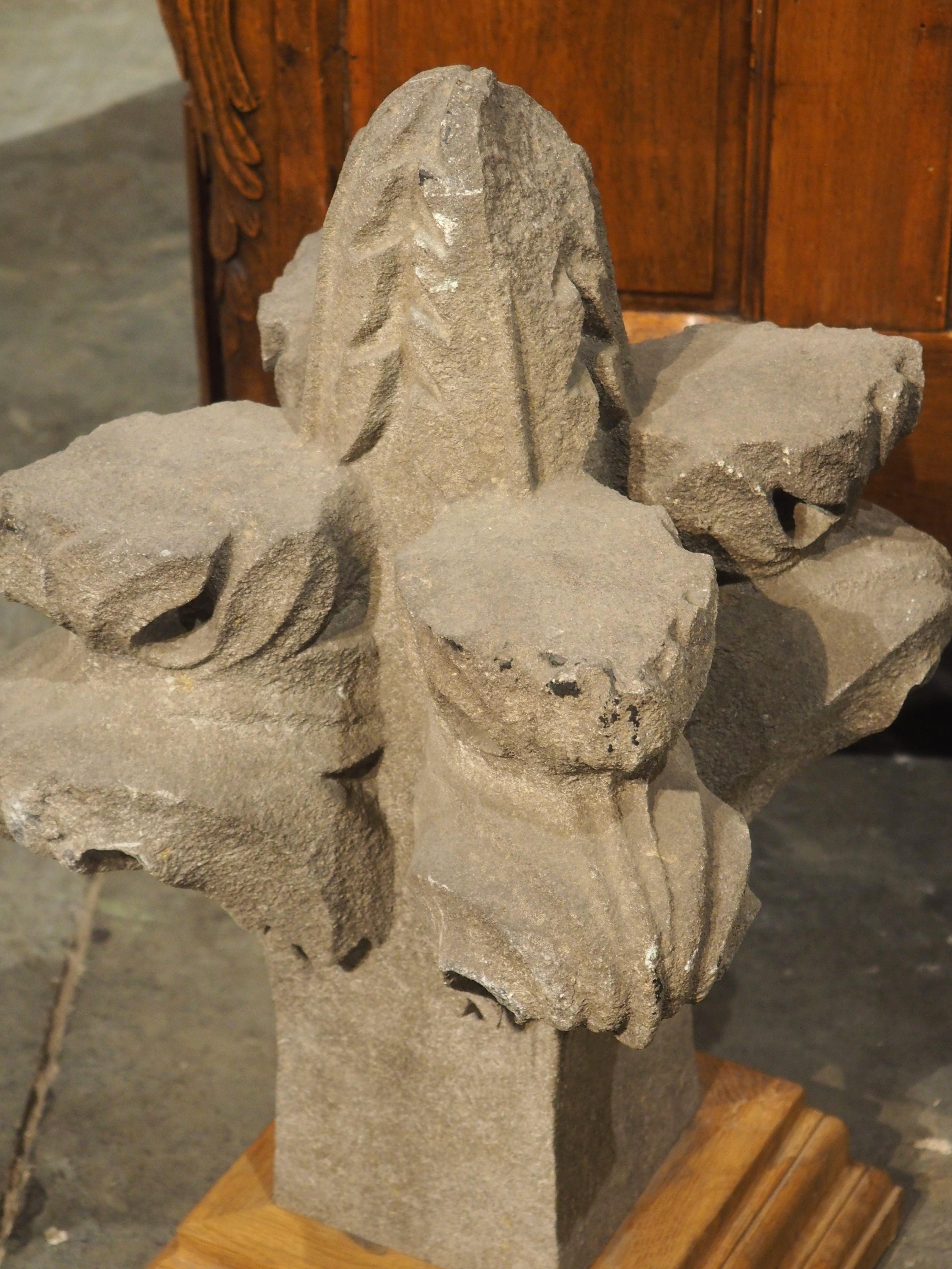 Originally an architectural for the roof of a Belgian building, this granite finial dates to the 1700s. The foliate finial has deep carvings, making it presentable from all sides. Large, curled leaves arise from a square block, forming an open leaf