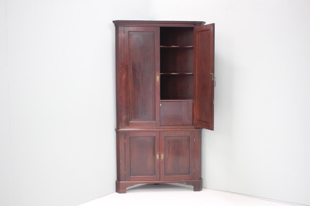 An 18th century English, Country house Georgian corner cupboard in mahogany with its original keys and a lovely colour.	
.