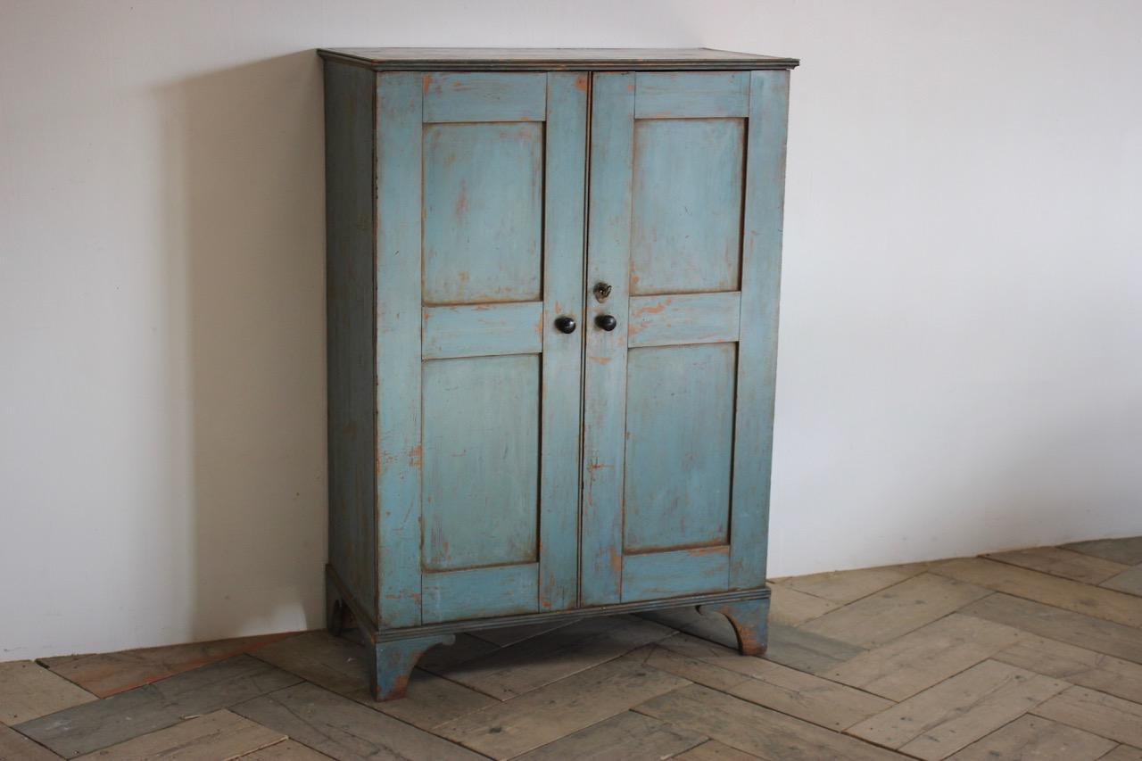 A very charming late 18th century blue painted housekeepers cupboard retaining the original paint and lock.