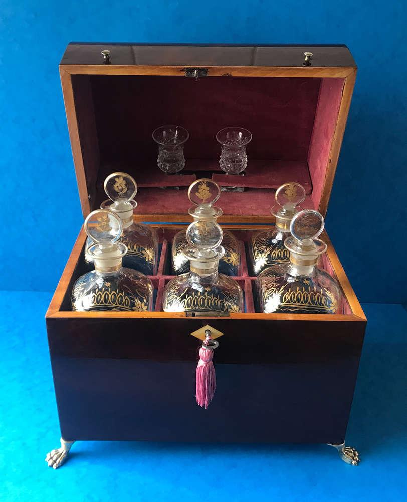 This is 18th century 1790 mahogany Dutch Decanter Box. It sits on four brass claw feet has two brass knobs to the front of the box, it has six gilt brass decanter bottles to the inside and two cut glasses, it has a working lock and key it has its