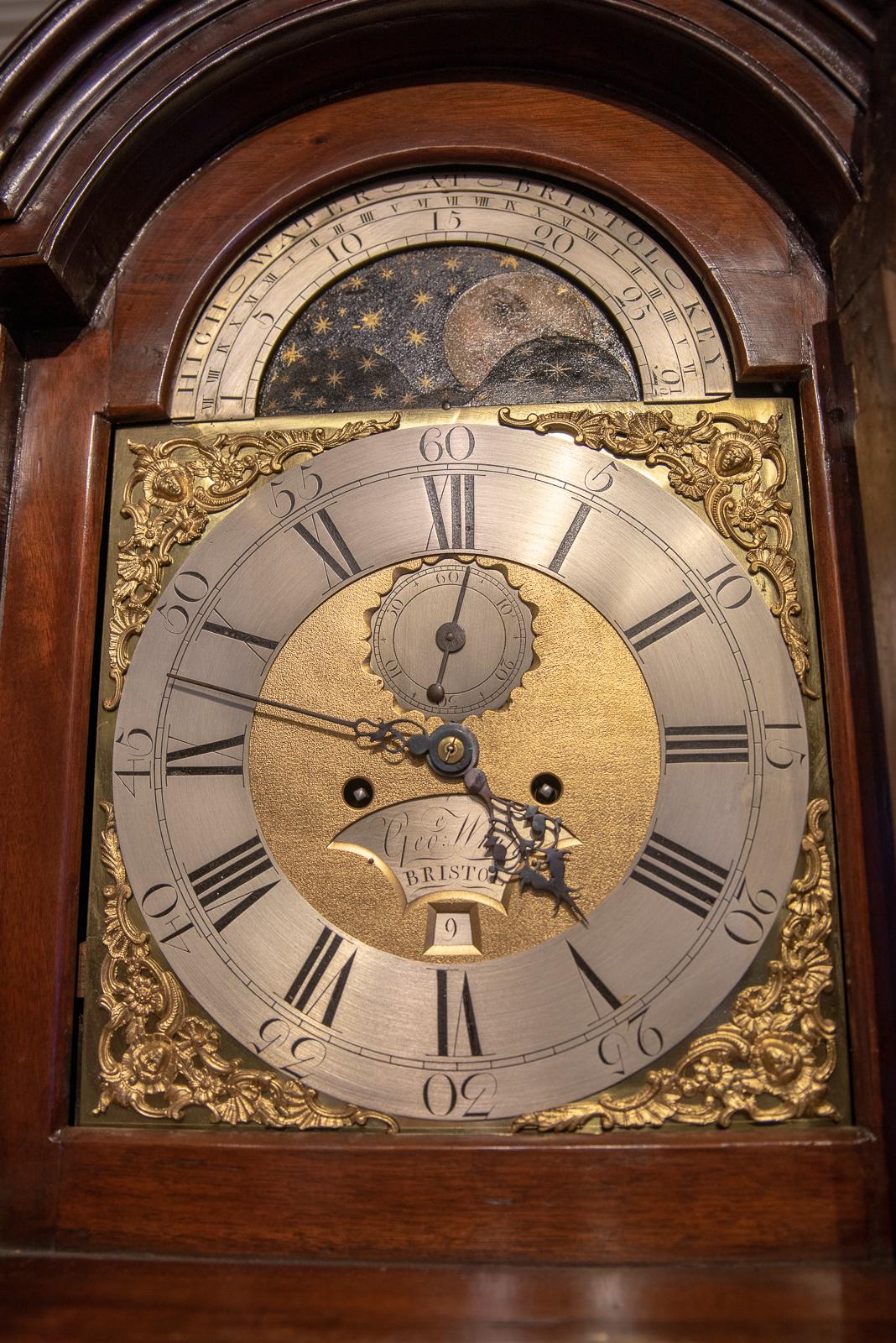 An 8 day arched brass dial moon phase and high water tidal dial clock. Striking the hours on a single bell, by George White of Bristol, recorded working 1771 - 1797. In a very small cuban mahogany case with reeded columns to the hood and quarter