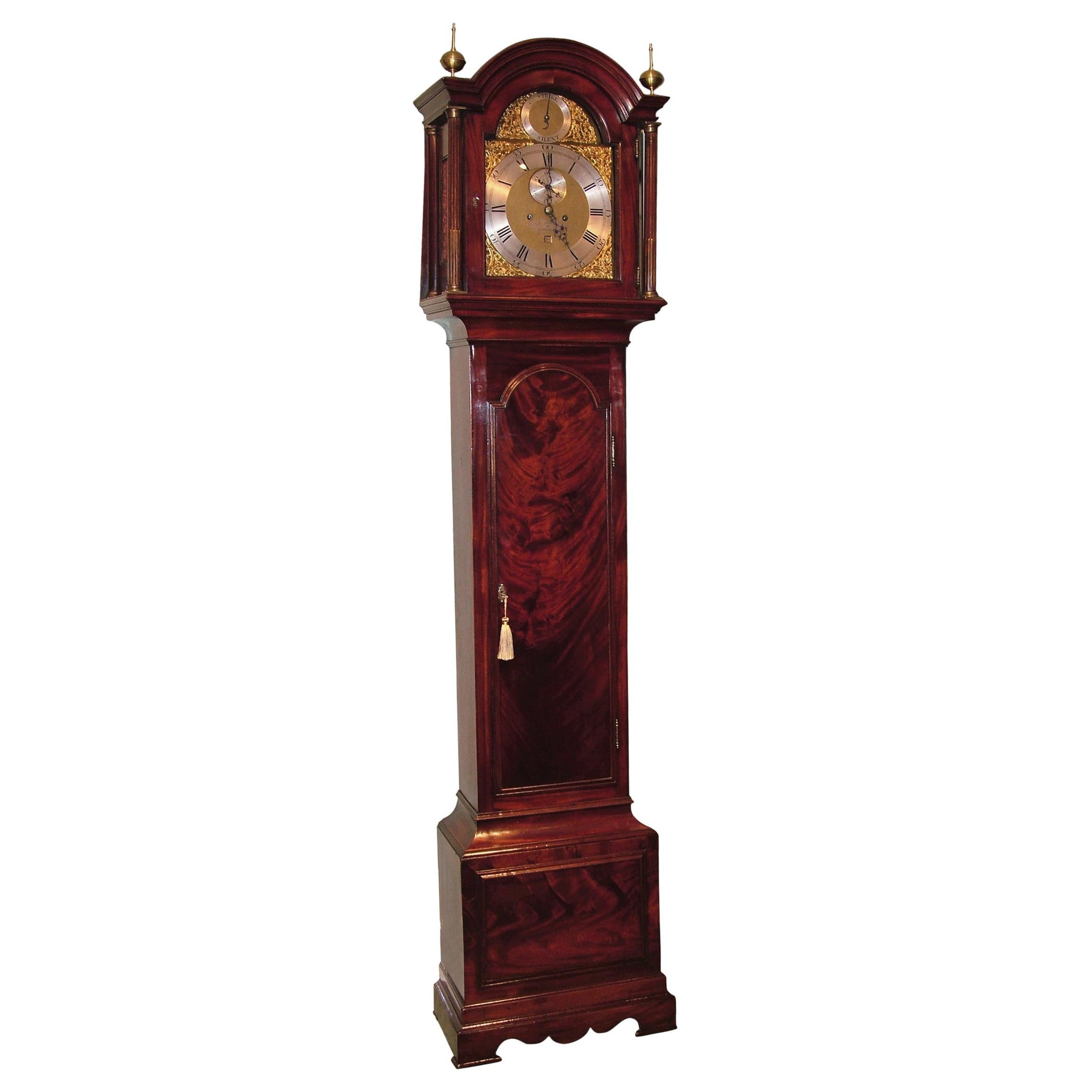 A late 18th century mahogany long case clock, by B. Francis of Gravesend, having arched top with brass finials and fluted columns, enclosing eight-day striking movement with silvered dial and gilt brass spandrels. The clock with flame figured door
