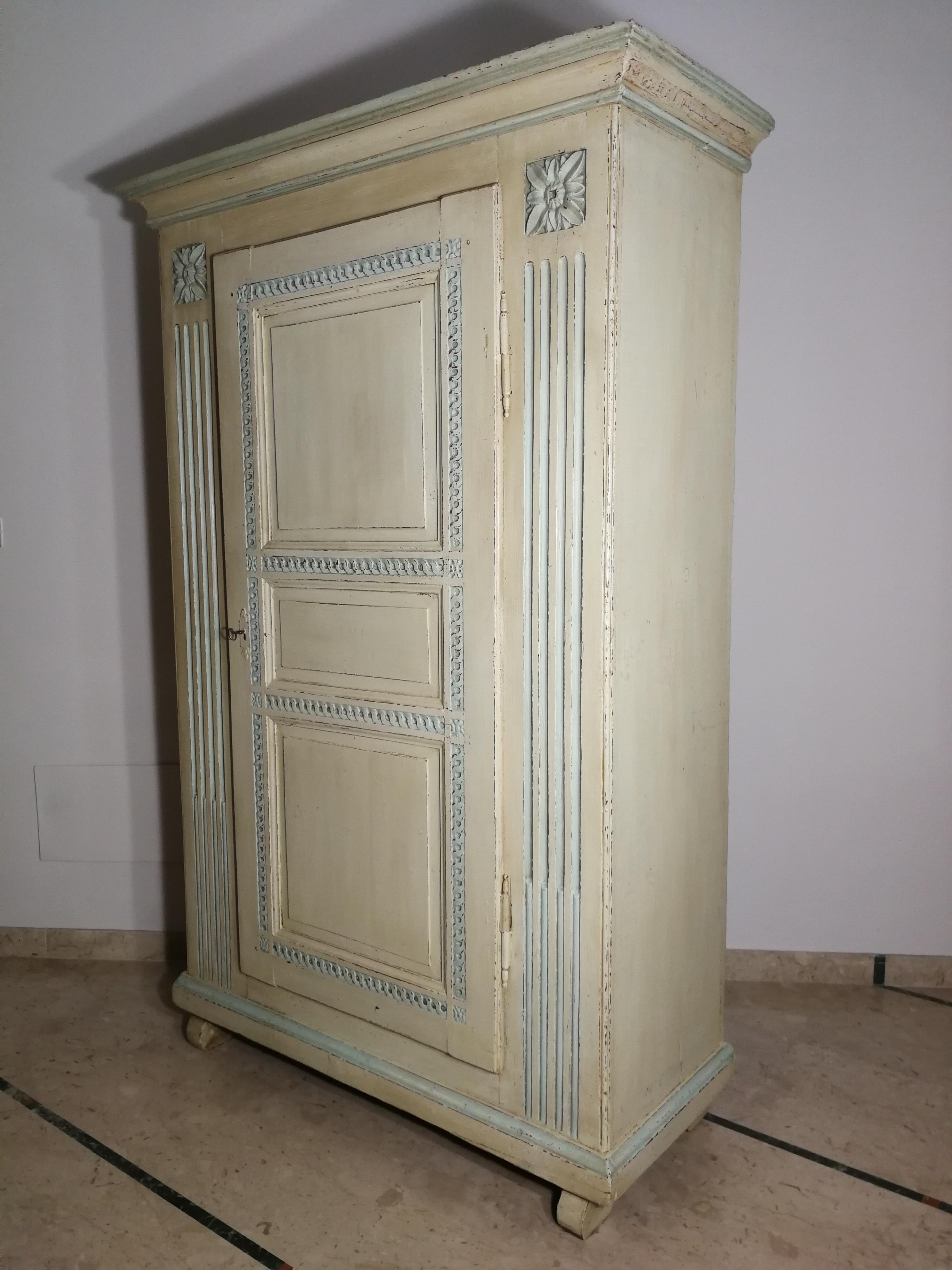 Wardrobe from the late 1700s painted with pastel colors.
It is composed of a single wing-shaped block with three molded and sculpted panels. The front is enriched with grooves and rosettes
Restored preserving the original paint and polished with