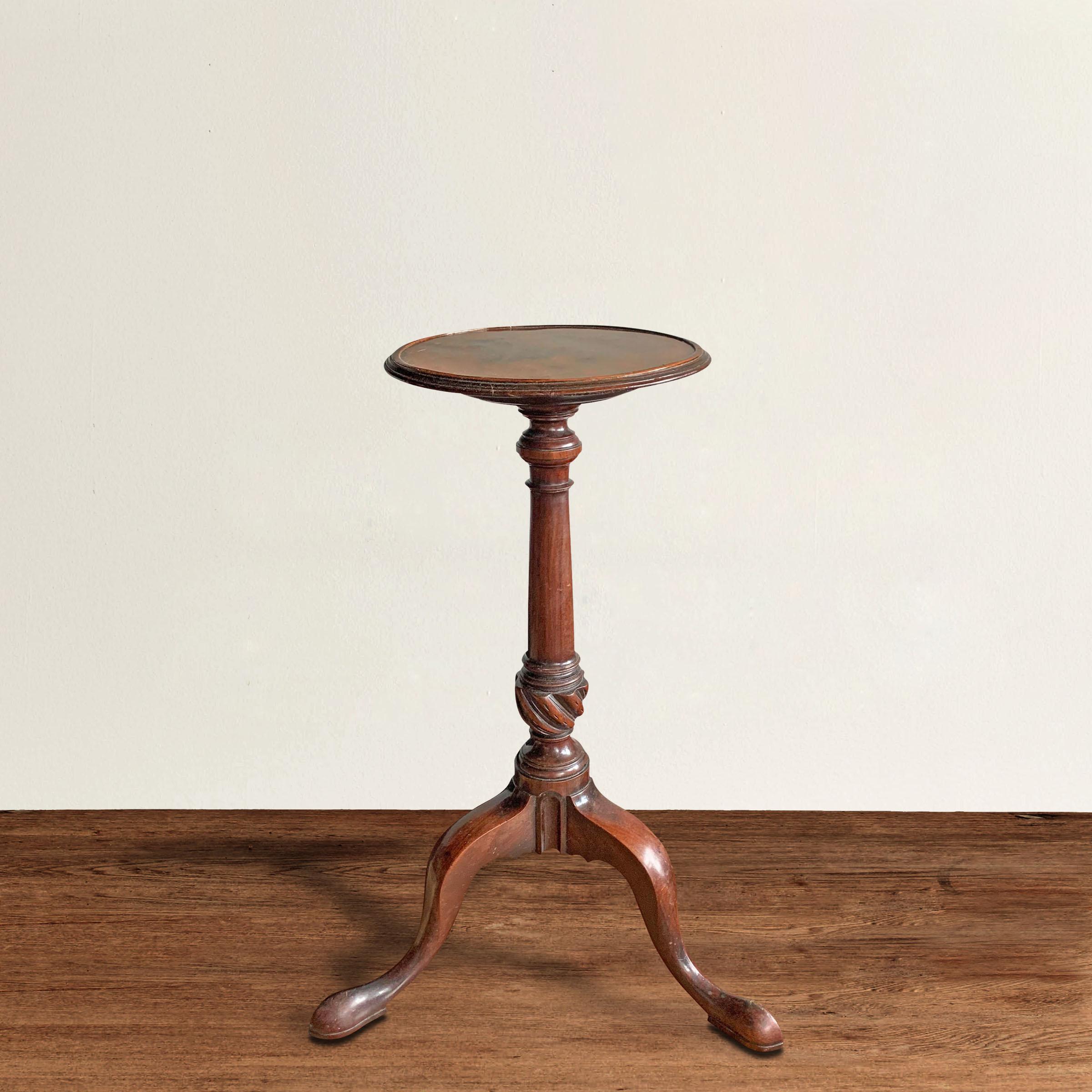 A fantastic 18th century American Queen Anne style mahogany candle stand with a turned column with a carved twisted knuckle, and three cabriole legs with pad feet. Originally intended to support of candle stick, this table is the perfect drink's