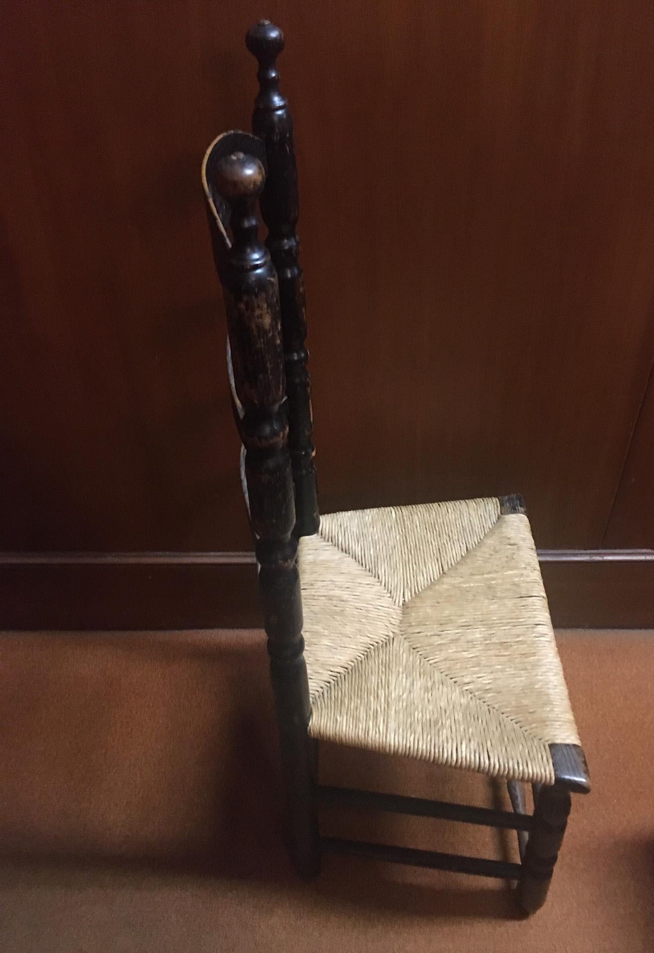 Questa sedia Coloni dei primi anni dell'America è caratterizzata da stecche ricurve nella parte posteriore, gambe anteriori tornite e doppi sostegni verticali su tre lati. I supporti anteriori sono anch'essi torniti, con montanti finali torniti che