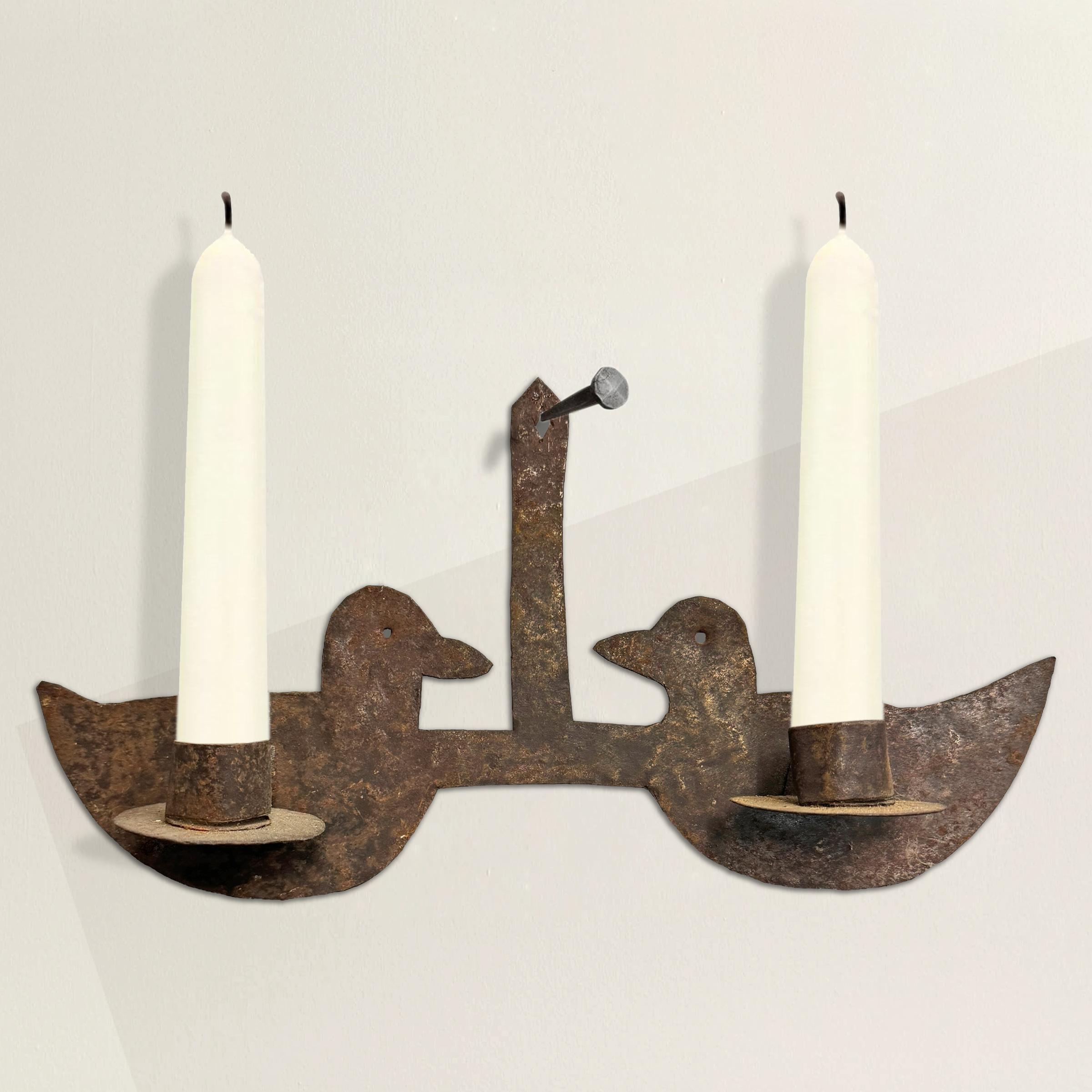 This exquisite 18th-century American candle sconce is a quintessential example of early American design, where simplicity meets utility with an artful touch. Crafted from thinly cut iron, this piece embodies the resourcefulness and craftsmanship