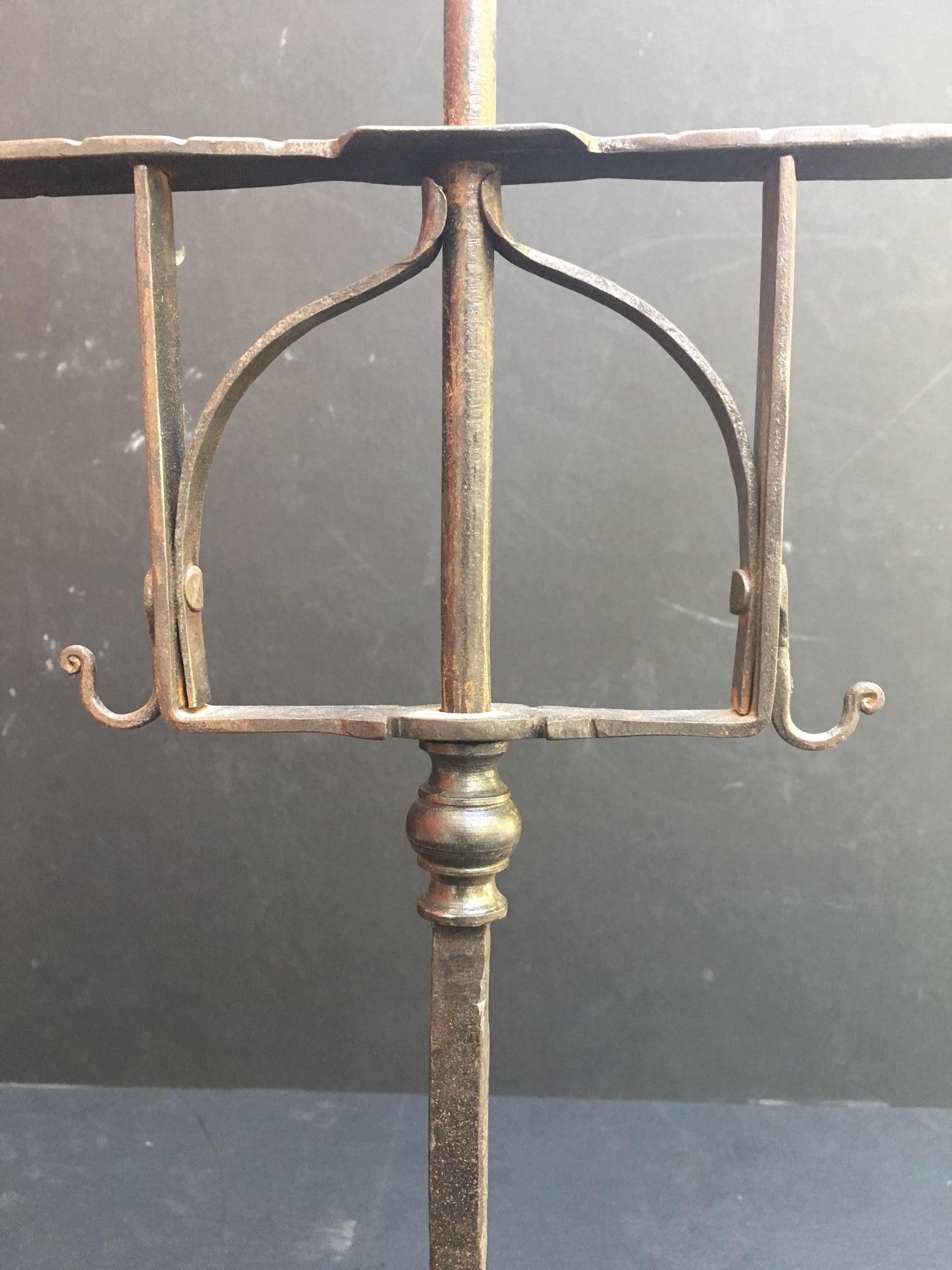 This very beautiful wrought iron candelabra stands on three penny feet. It has a tapered spike with an adjustable two candleholder bridge. This masterfully hand forged iron with stunning details is rustic but elegant. It is an authentic 
piece of