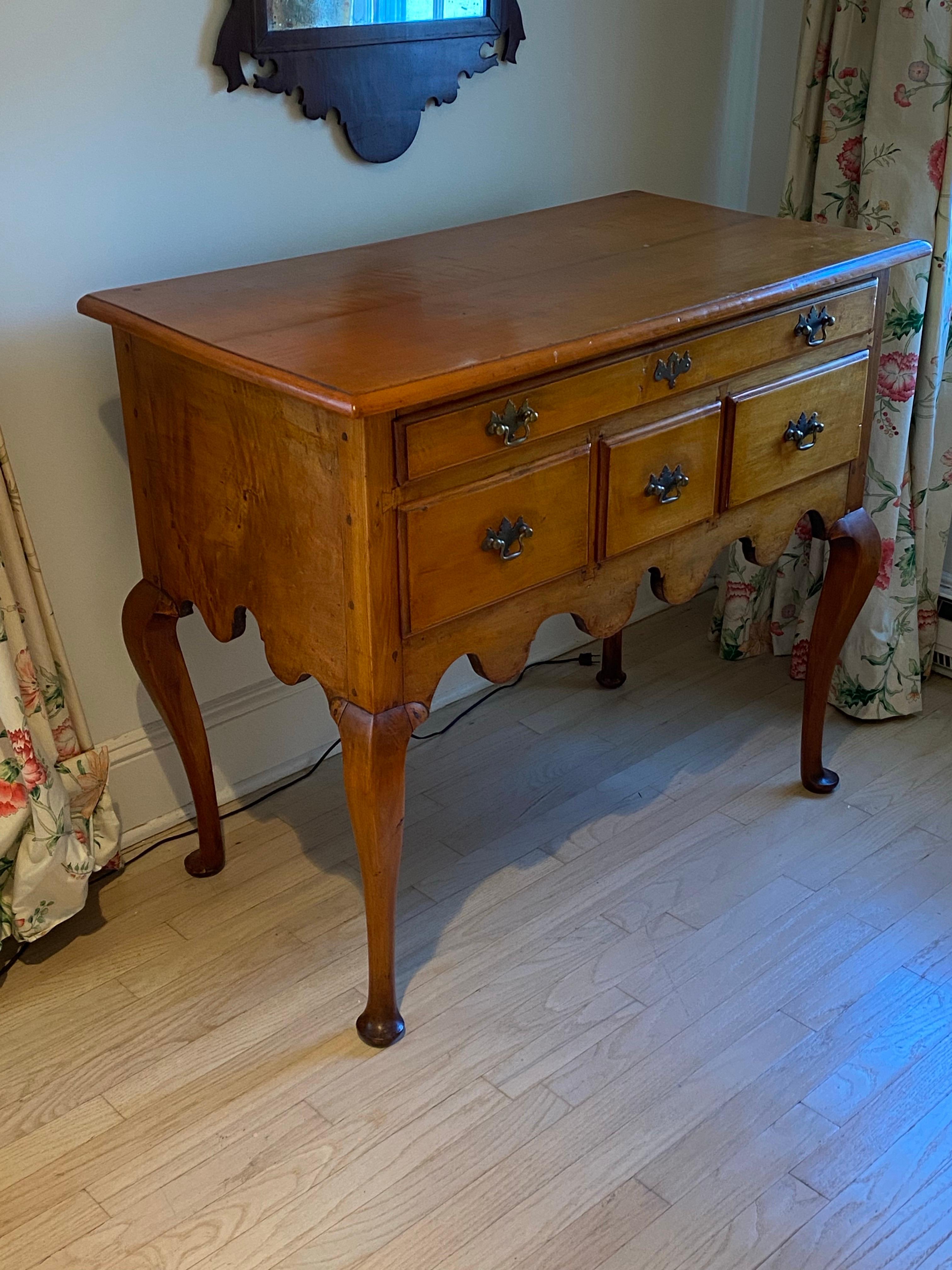 Table basse en cerisier Queen Anne du XVIIIe siècle
Il comporte quatre tiroirs, chacun équipé de poignées en laiton à la fois simples et élégantes. La table repose sur des pieds cabrioles, se terminant par des pieds pad.  Le tablier sous les tiroirs