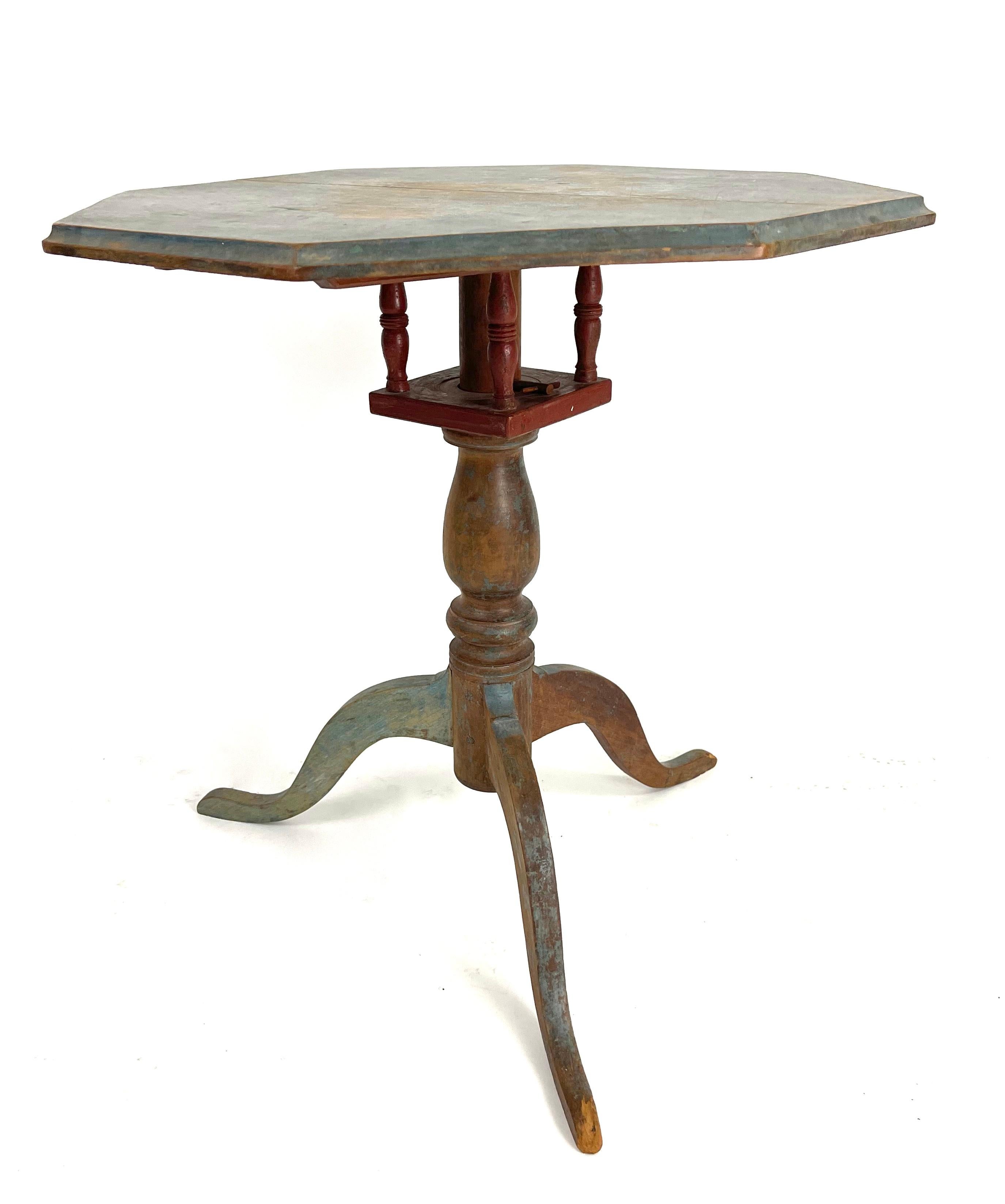 An 18th century American painted tea table in wonderful old, chalky blue paint, the octagonal top with molded edge over a birdcage and baluster-turned standard supported by a tripod base. Old blue paint over old red paint. Beautiful dry finish and