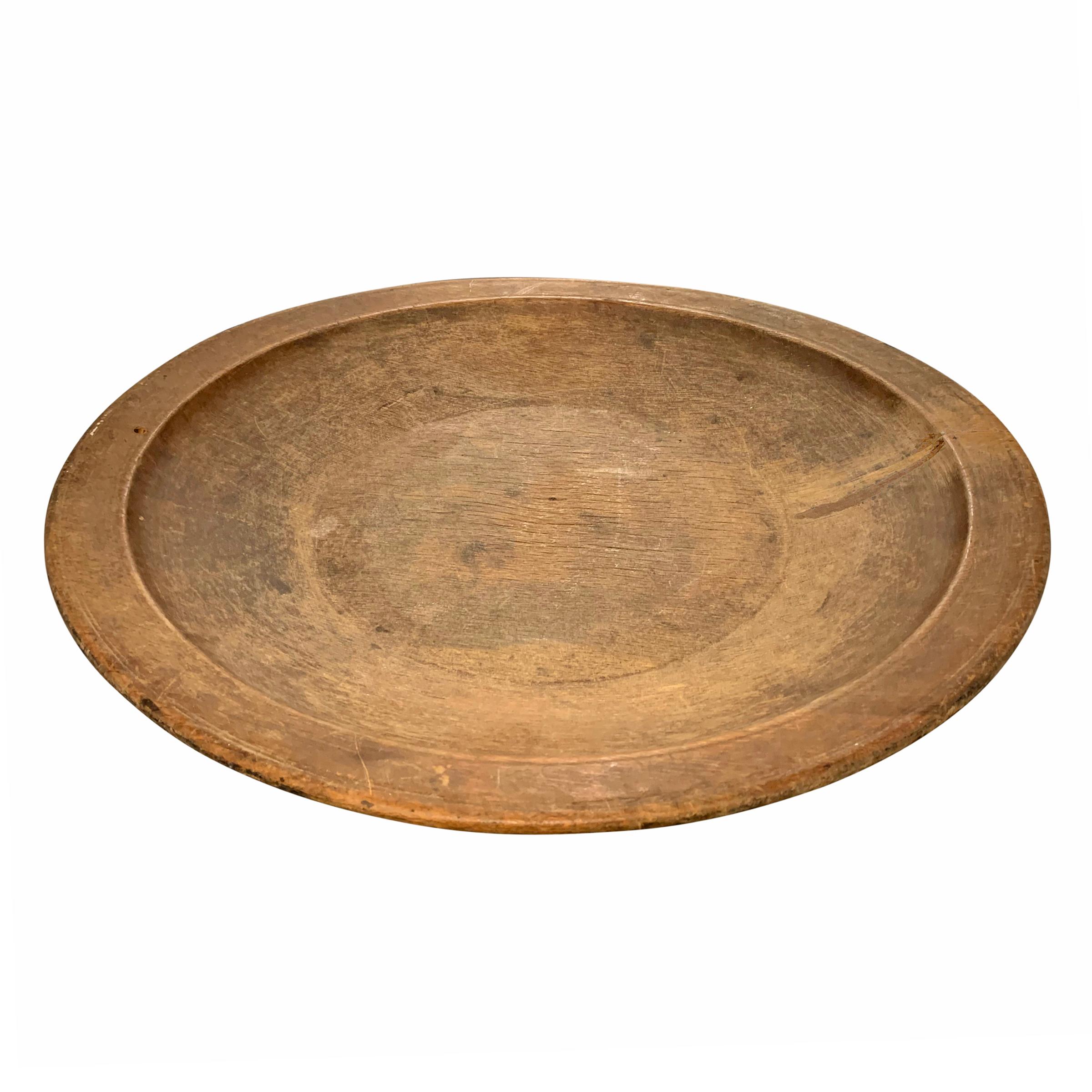 An incredible 18th century American turned wood tray with a wide rim, wonderful incised lines on the exterior, and a patina only time can bestow.