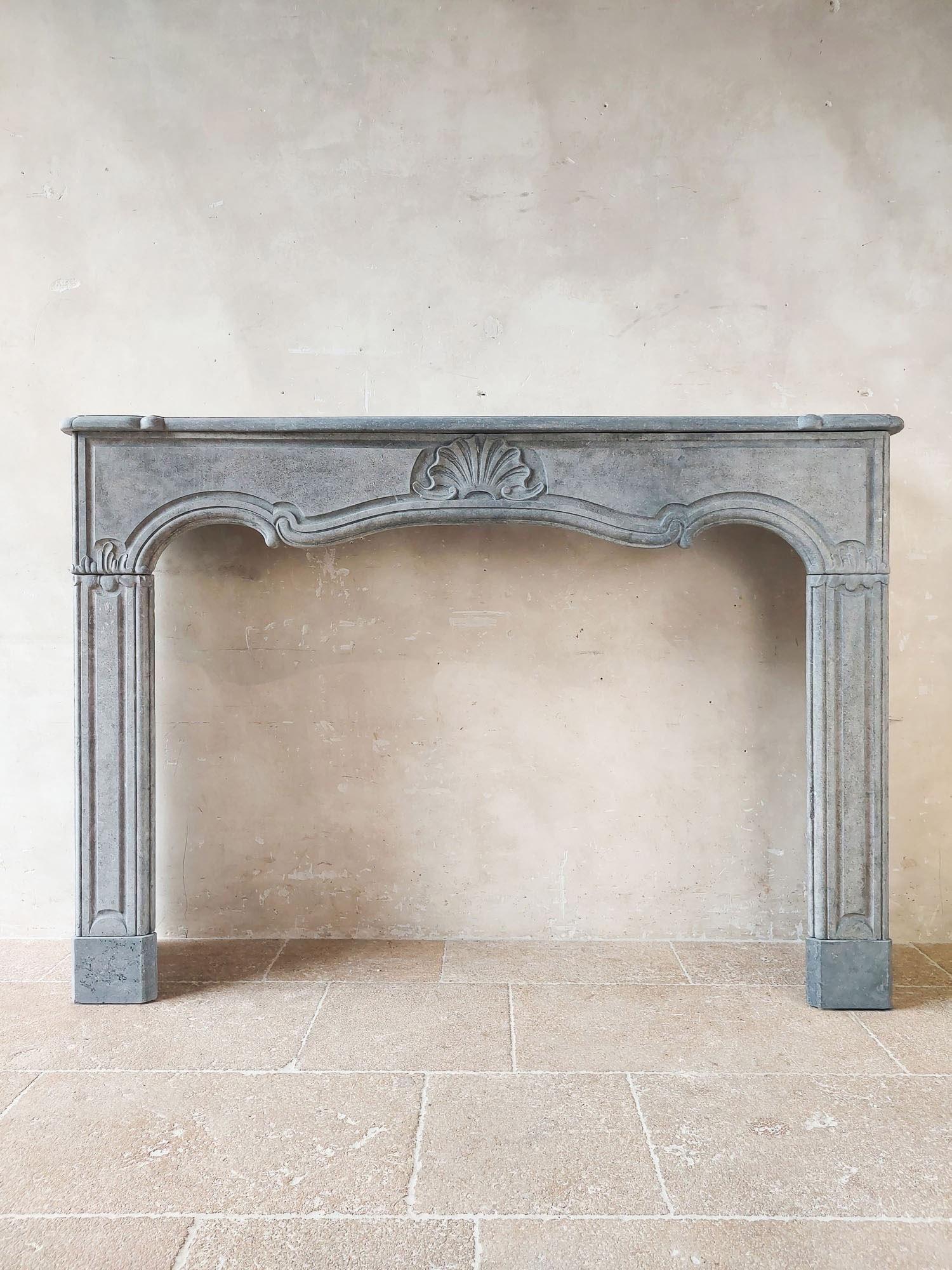 18th century Amsterdam bluestone fireplace in Louis the Fourteenth style. This mantle is made of the 'petit granite' quality of Belgian bluestone. This mantelpiece may have been stored for a longer period of time, giving the bluestone a matte