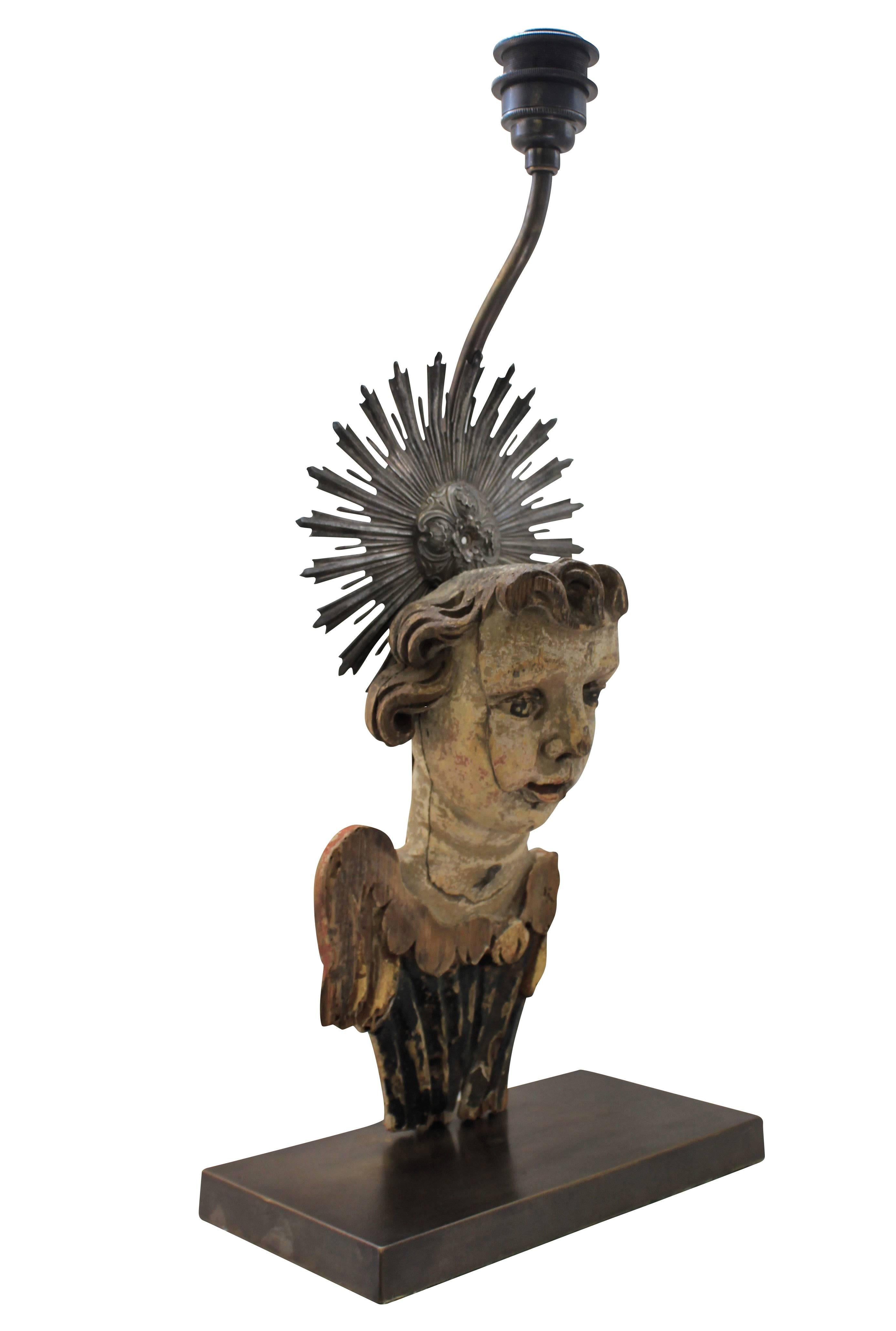 An Italian 18th century carved angel fragment with a silver nimbus, mounted as a lamp.