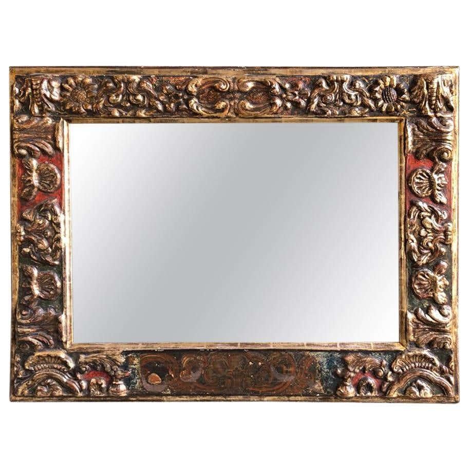 18th century antique Baroque style giltwood mirror. This giltwood mirror is a spectacular example of Italian Baroque style design. The mirror displays many of the characteristics of the Baroque, including grandeur, richness, drama, vitality and