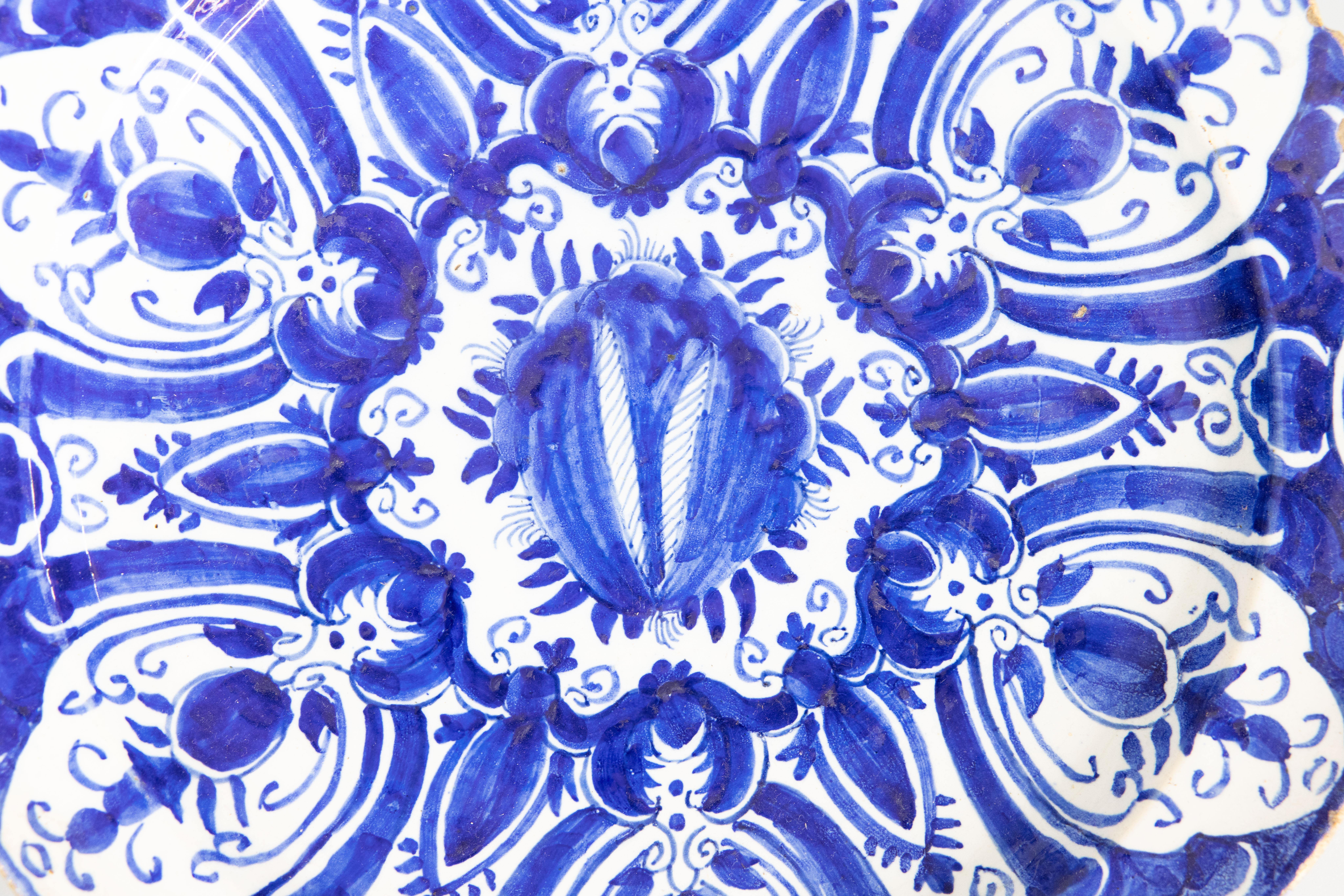 18th century Delft earthenware charger with blue and white stylized flowers, marked with a D on the reverse (probably Jan Theunis Dextra at the De Grieksche factory).