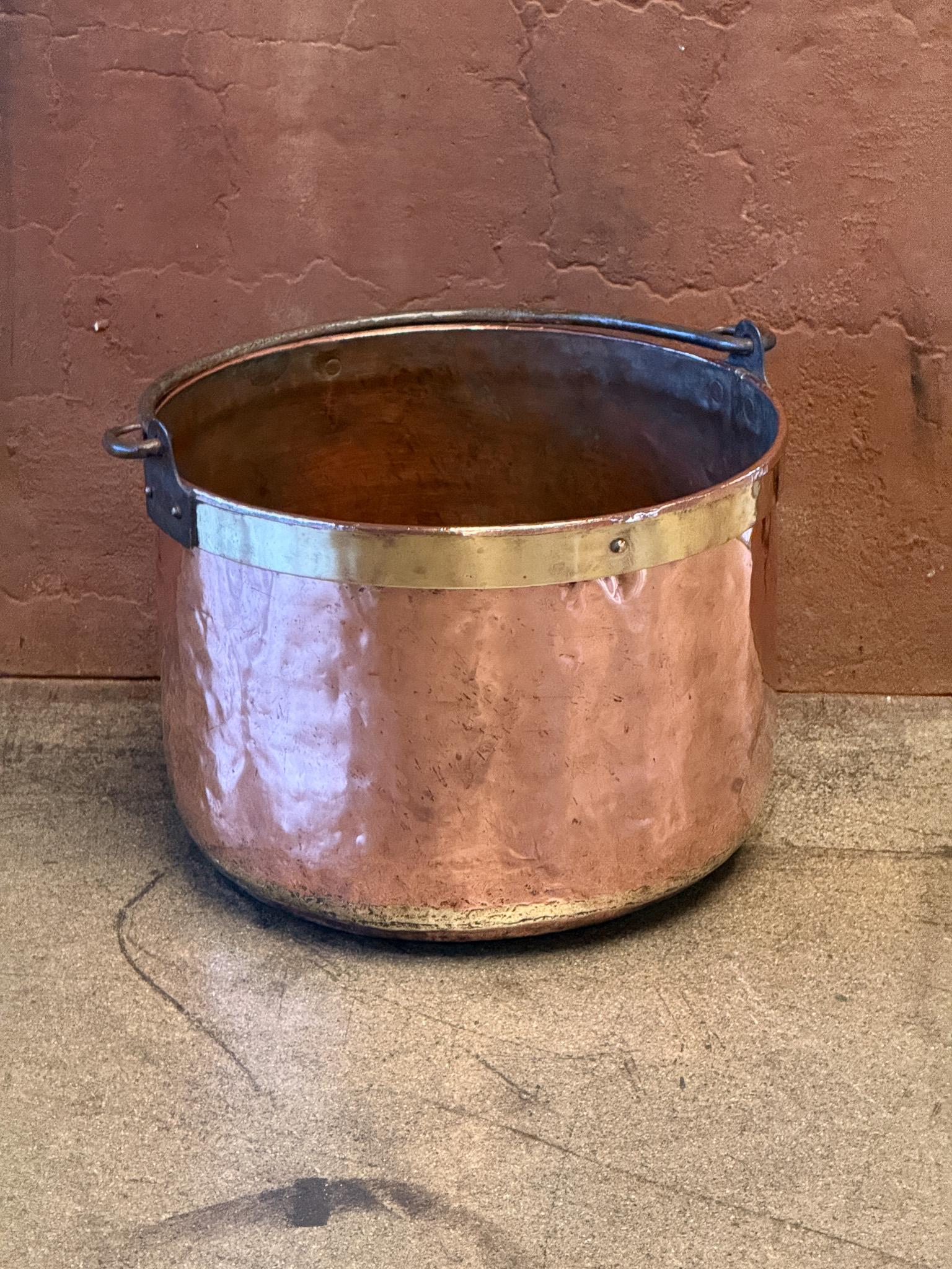 18th century Dutch log basket. The firewood basket is made of polished copper and a polished brass rim on top and has a wrought iron handle. Also called 'aker'. Used to draw water from the well and cook over an open fire.

The log holder is in a