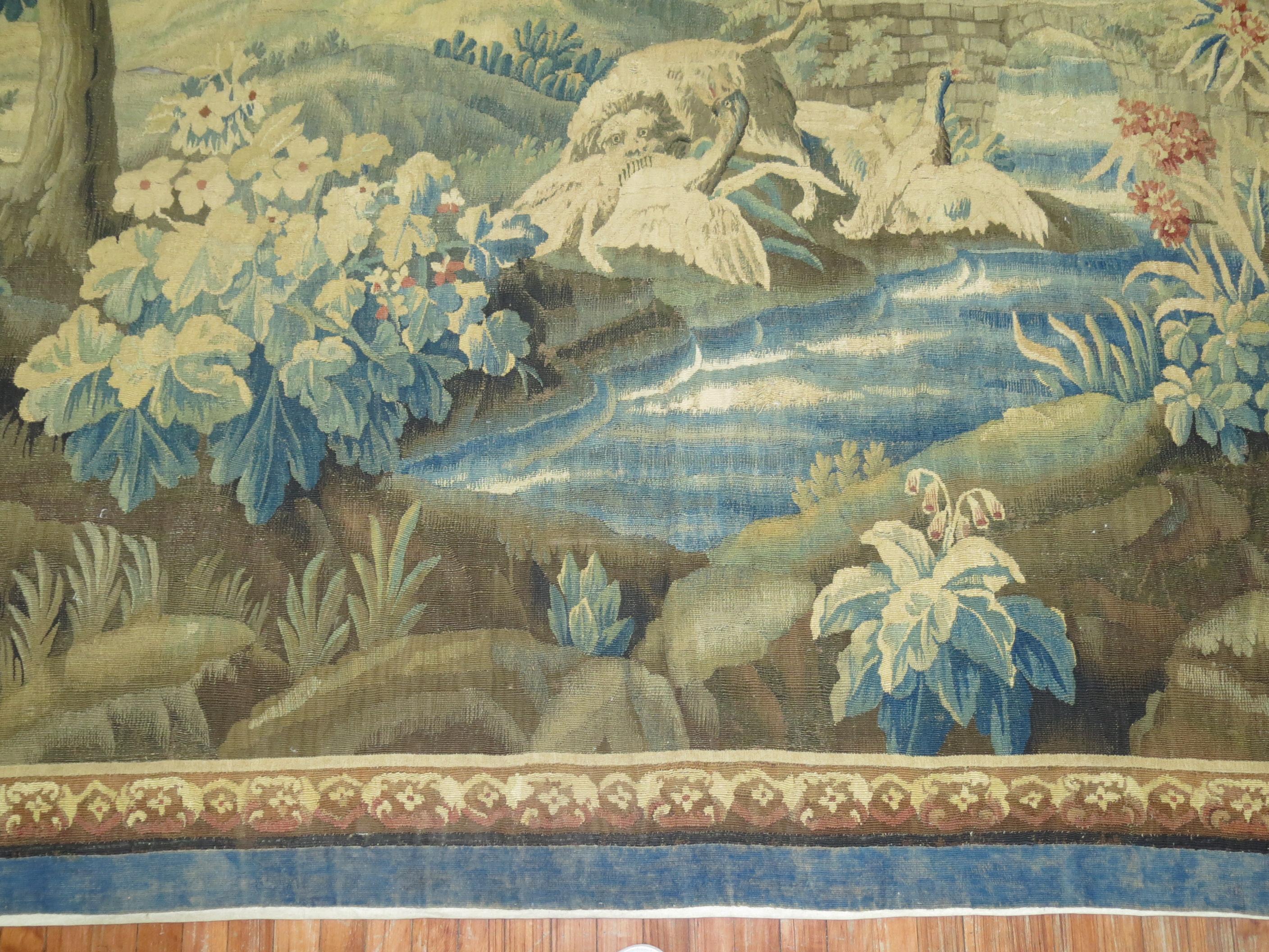 Birds and a dog in a wooded landscape with structures in the distance within a floral border. Measures: Height 8 '1'' x Width 10'9'' 

 An antique tapestry would be one that was produced at least 100 years ago woven to portray an artistic scene