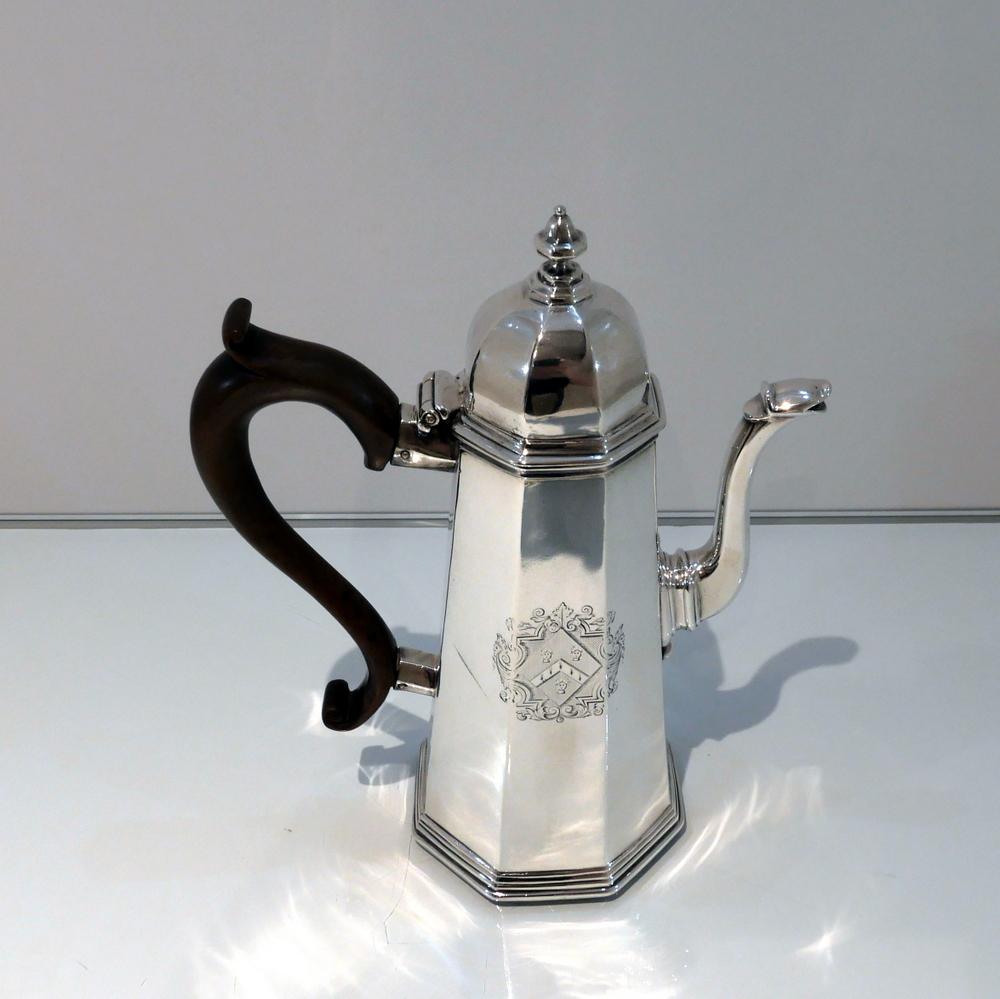 A fine quality and incredibly collectable early Georgian Britannia standard coffee pot designed with tapering angles and an elegant hinged domed lid. The centre front of the body has a beautiful contemporary hand engraved armorial for