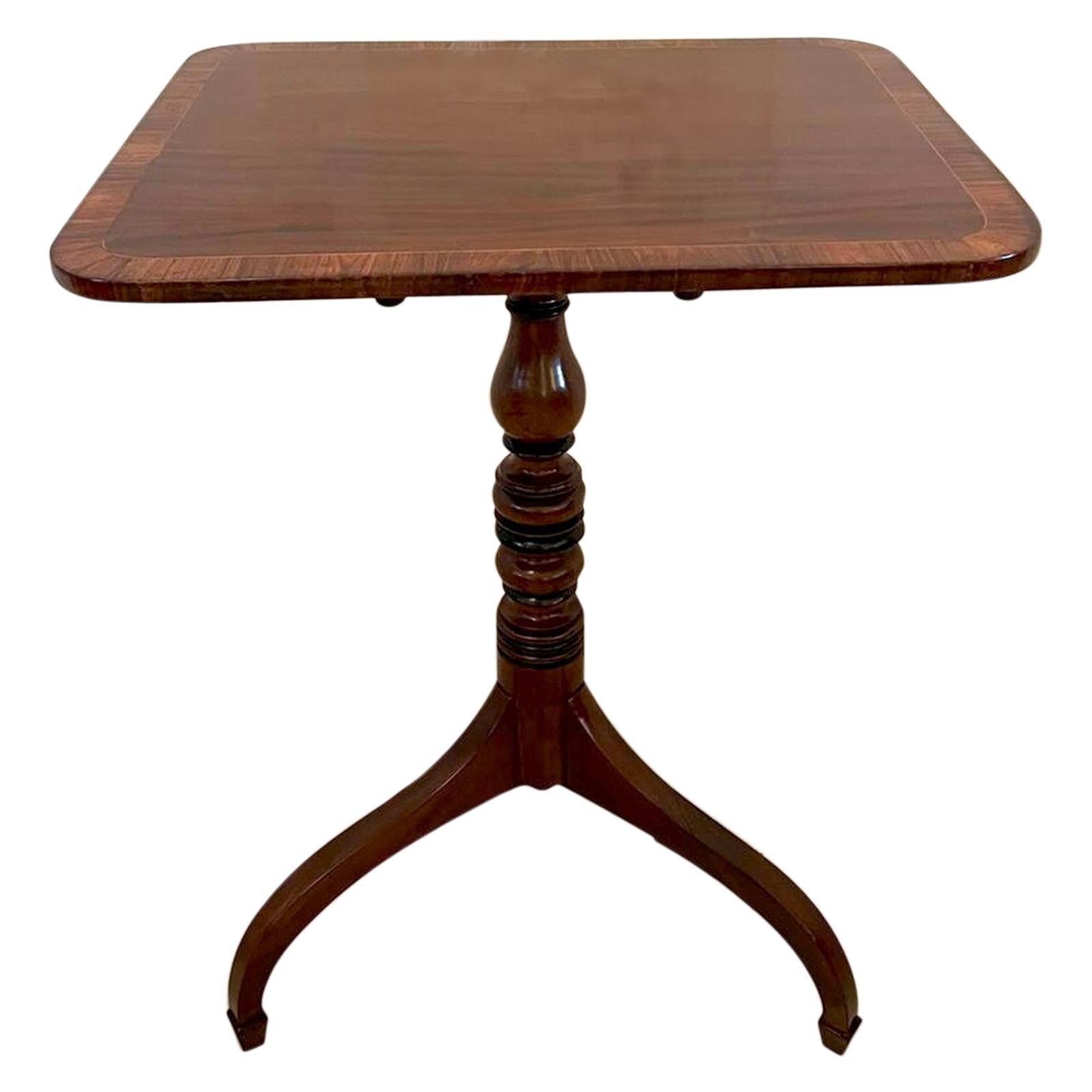 Antique 18th Century George III quality mahogany lamp table having a quality mahogany tilt top beautifully crossbanded in rosewood with a satinwood stringing. It is raised on a splendid turned shaped column and standing on unusual and very