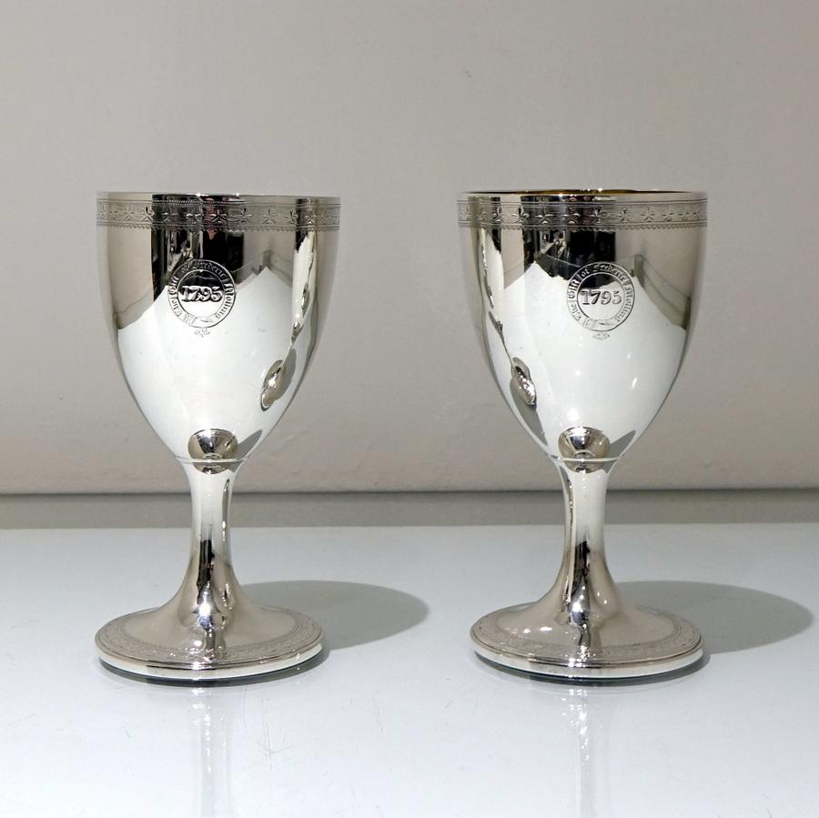 A splendid pair of Georgian vase shaped wine goblets decorated with upper and lower band of intricate bright cut engraving. The centre fronts and backs of the bowls have elegant engraved contemporary crests and initials.

 

Weight: 13.8 troy