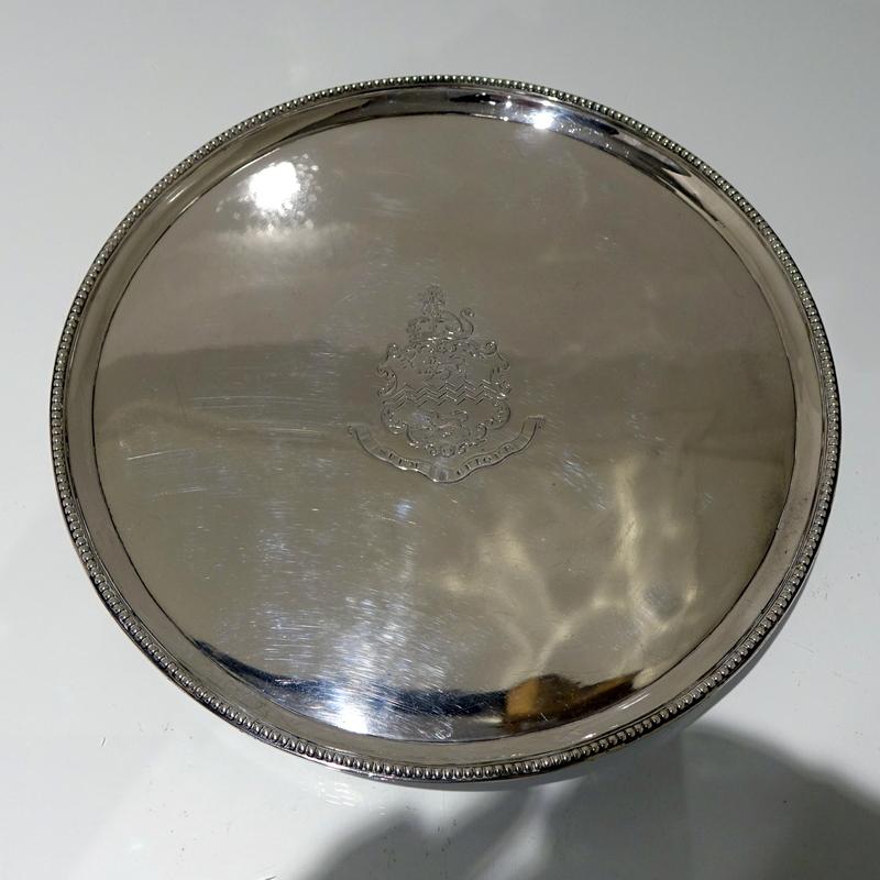 A stylish 18th century circular salver decorated with an outer applied bead border. The salver sits on three elegant feet which has additional outer bead decoration for lowlights. The center front has a beautiful contemporary armorial for