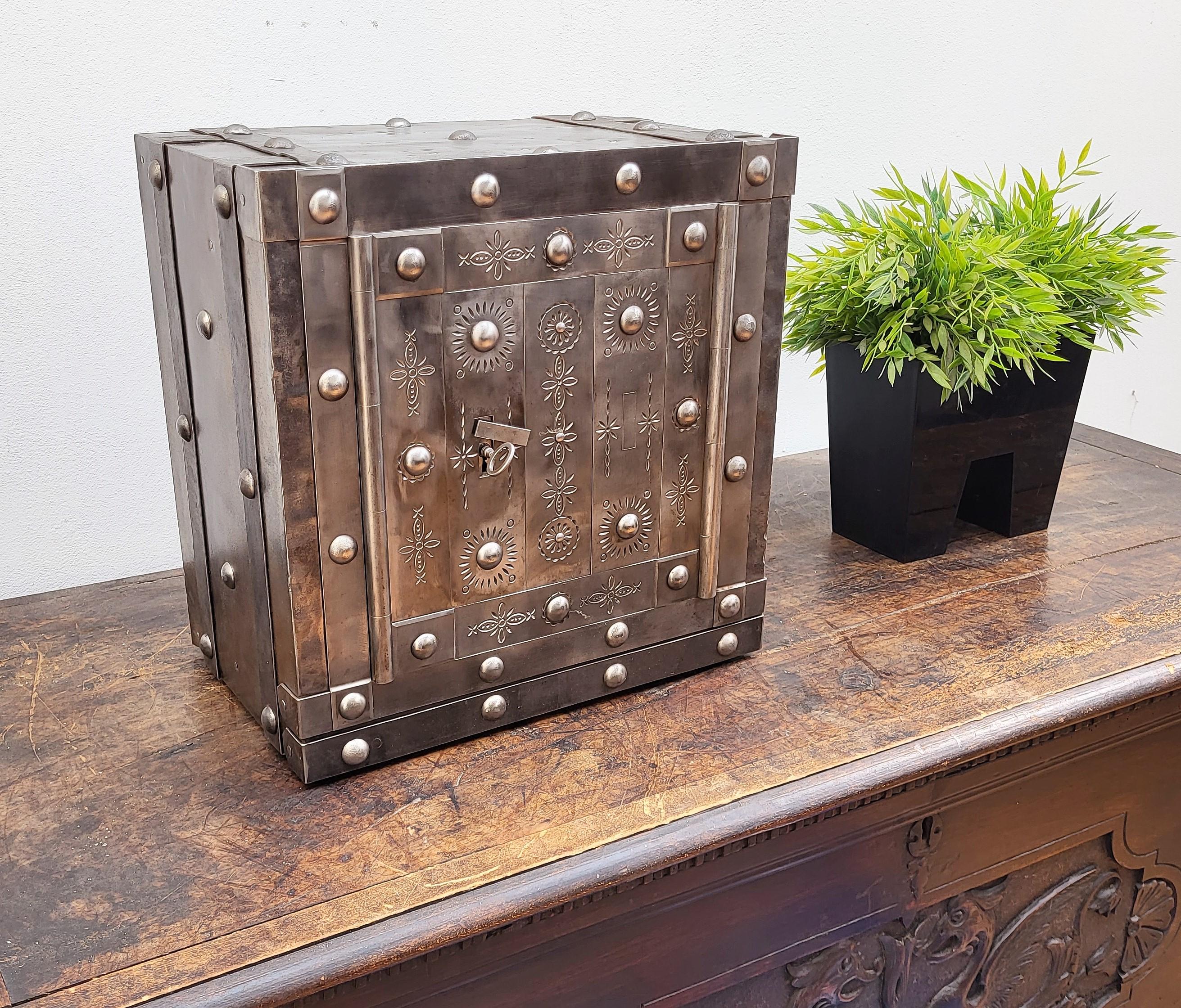 This beautiful Italian antique safe is a collector piece with typical all-around hobnails, dated circa 1790-1820, has a great metal color with patina of time and amazingly rich decorations, characterized by the central door with great burin incision
