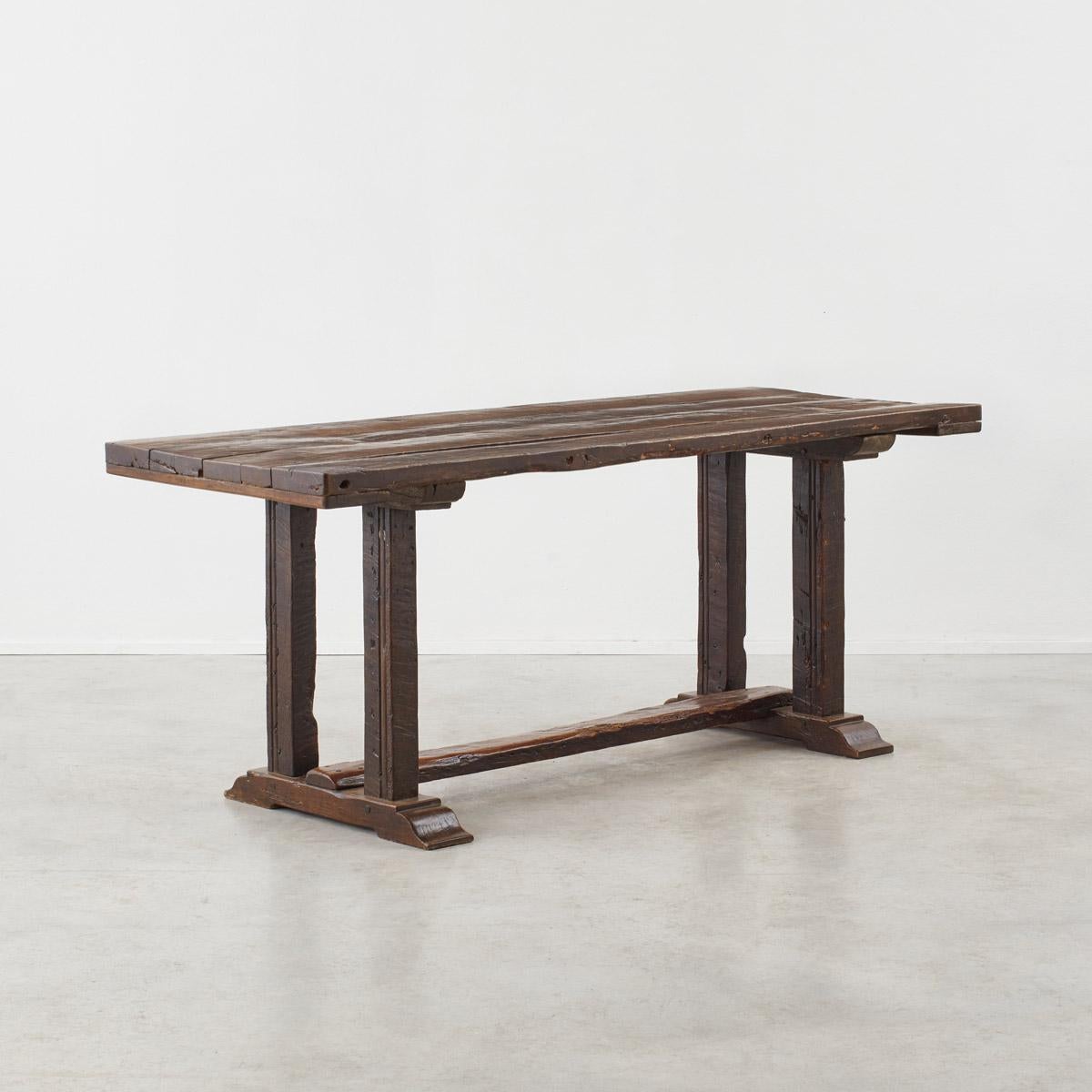 A rustic refectory table with a lovely deeply patinaed stained and wax finish. The table shows all the desirable hallmarks of age for one of its type – open wood grain, splits, dents and bags of patination to its top. It looks like it has possibly