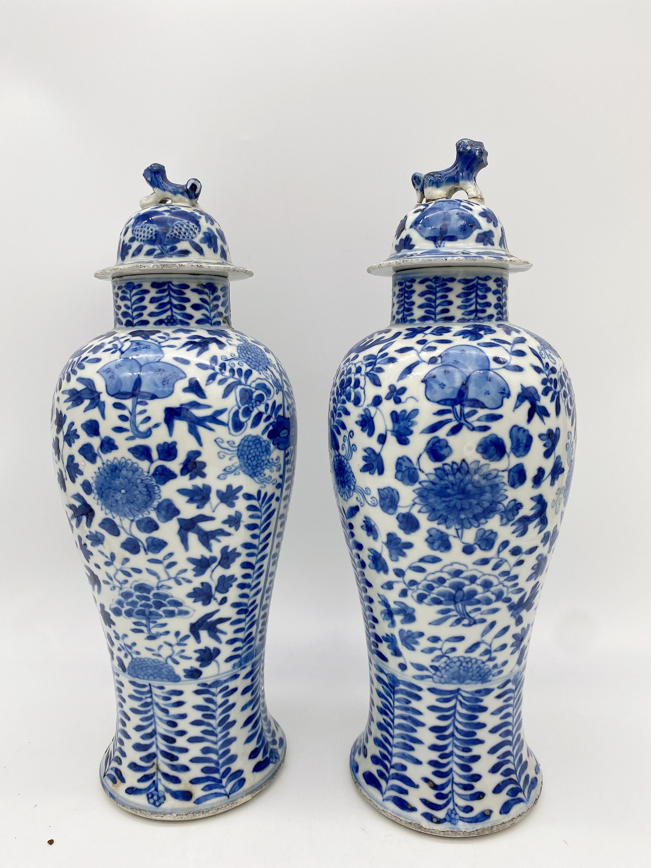 Paire de jarres et couvercles en porcelaine bleue et blanche de la dynastie Qing, 2 des 5 ustensiles sacrificiels, les couvercles avec des lions en forme de fleurons, décorés avec des fruits et des branches, les jarres sont endommagées au niveau du