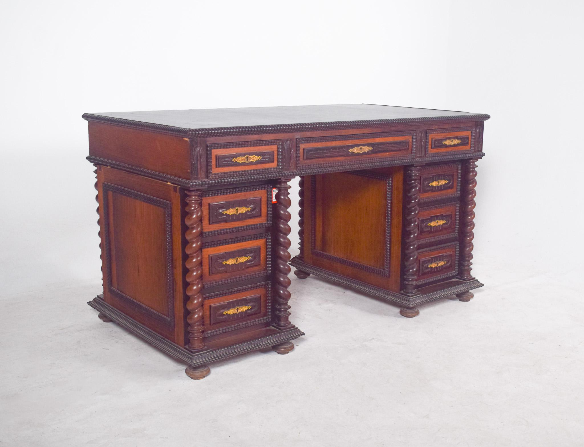 Twisted and shaken desk, 18th century, in rosewood. With spiral-turned columns that frame the side drawers, giving the whole an imposing feel and movement. The carved frames that run along the edges and fronts of the drawers reinforce the meticulous