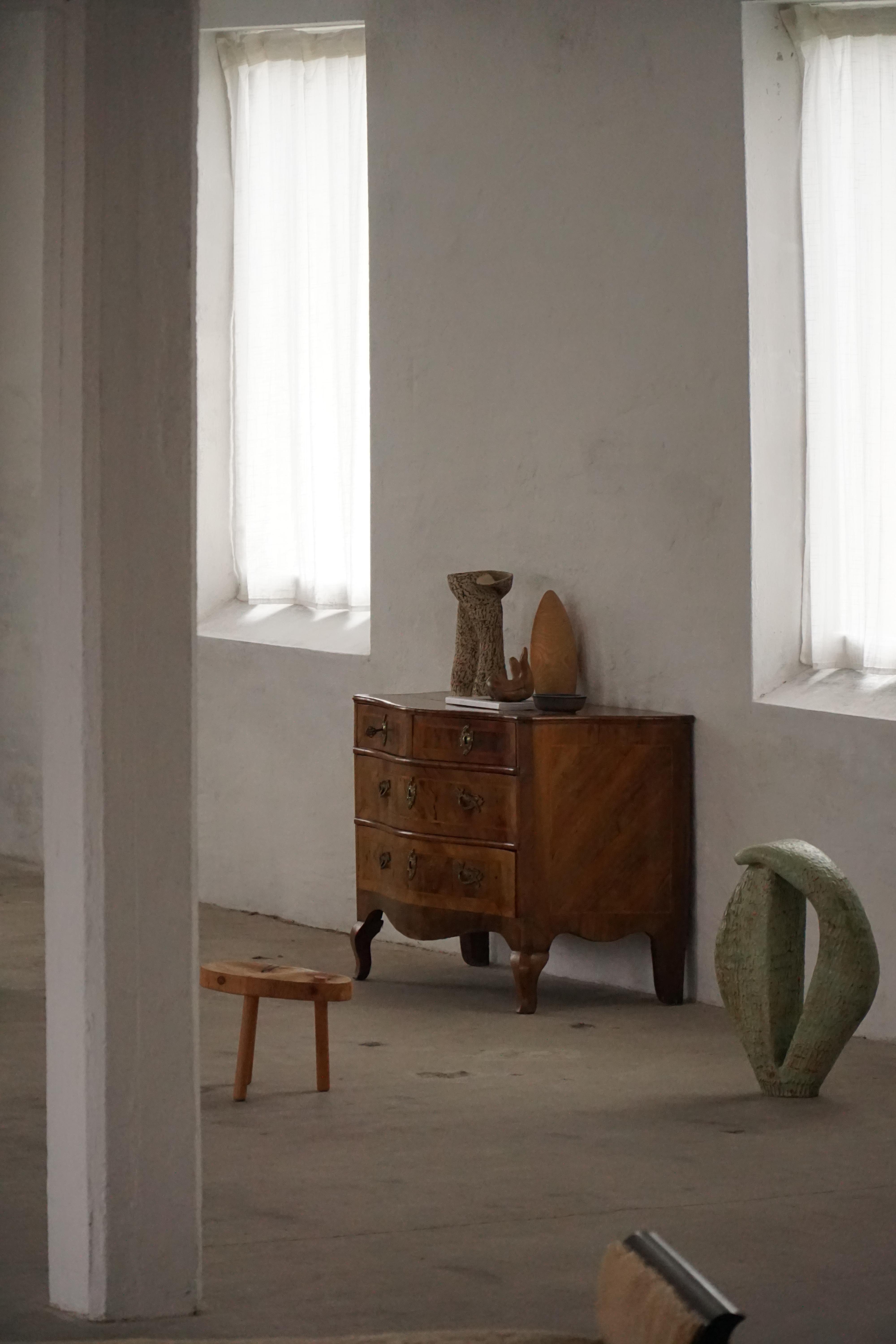 Una cassettiera barocca danese del 18° secolo, tranquillamente nobile, realizzata in caldo legno di noce e modellata dal morbido movimento di marea di un frontale a serpentina. La sua presenza è sobria ma duratura: un pezzo che ha vissuto per secoli