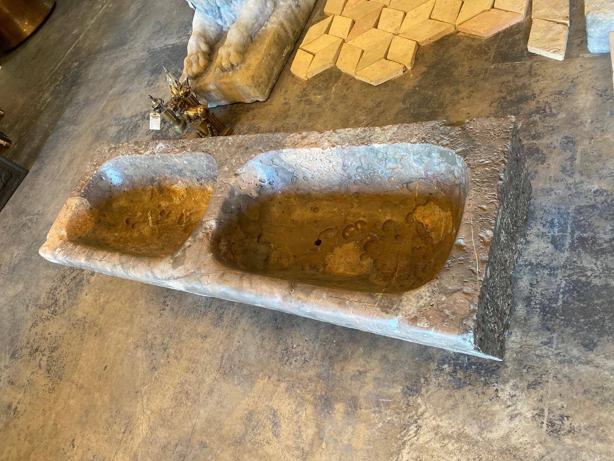 This unique stone trough features double basins and ring in the center to tie up your horse.

Measurements: 18” D x 56” L x 11” H.