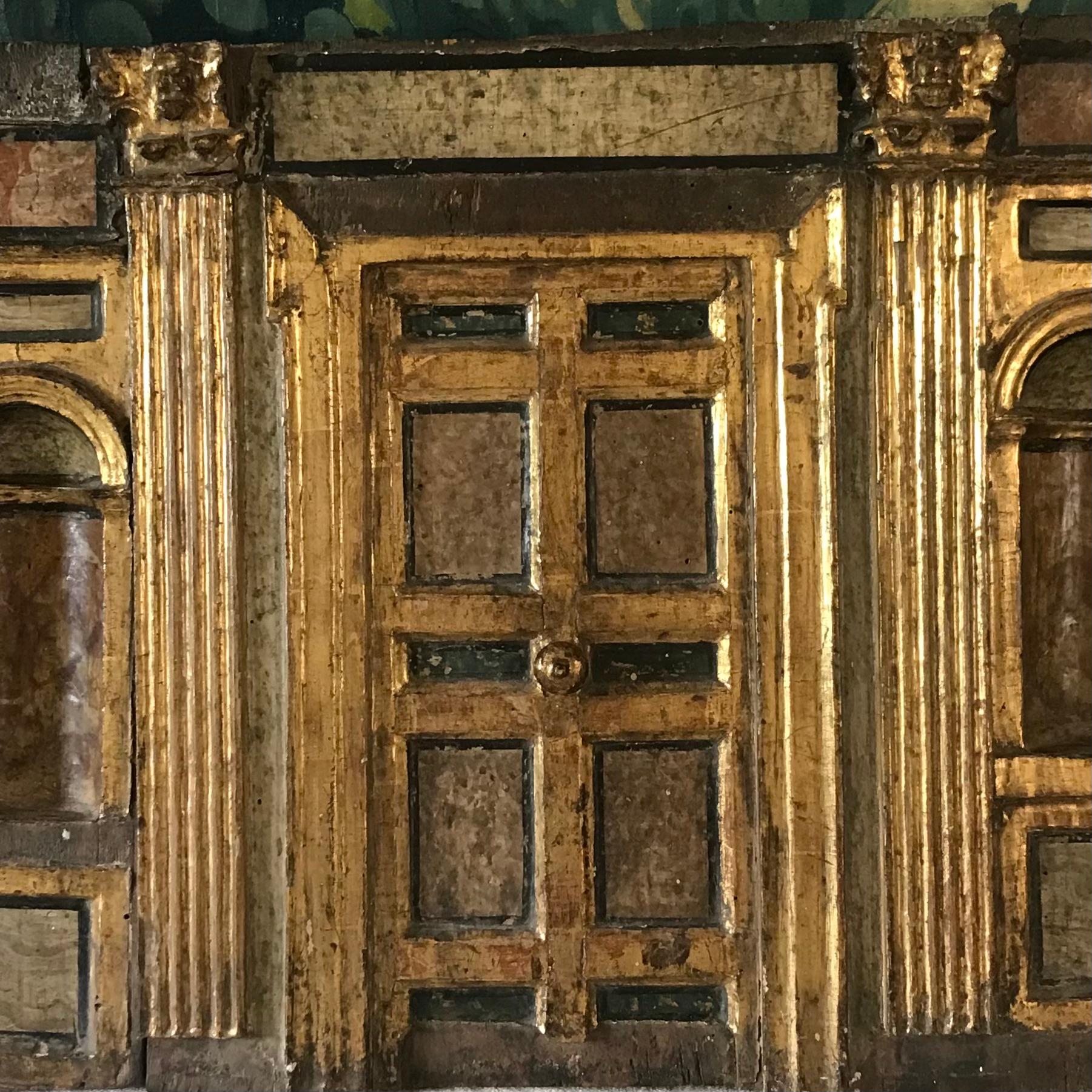 A late 18th century Italian architectural wood carving - hand carved painted and gilded wood - depicting a  facade of a building - an ornate door with deep recesses either side of the door in a hand marbled painted finish and gilded Corinthian